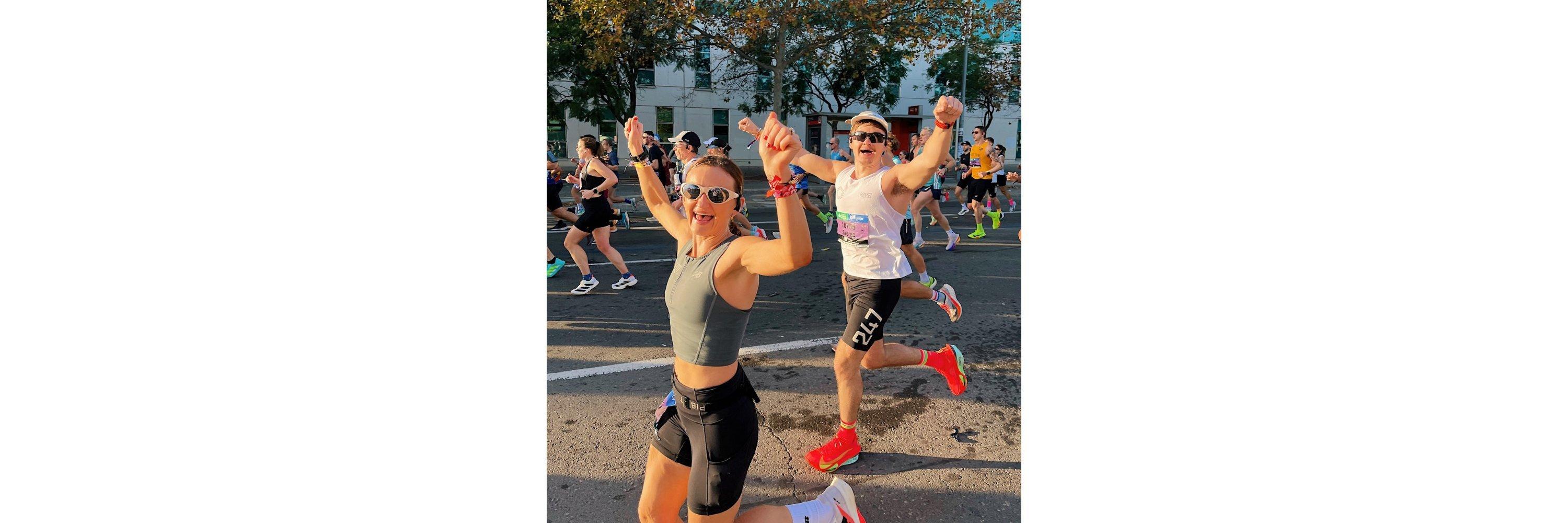 Two people wearing running clothing celebrating during a marathon