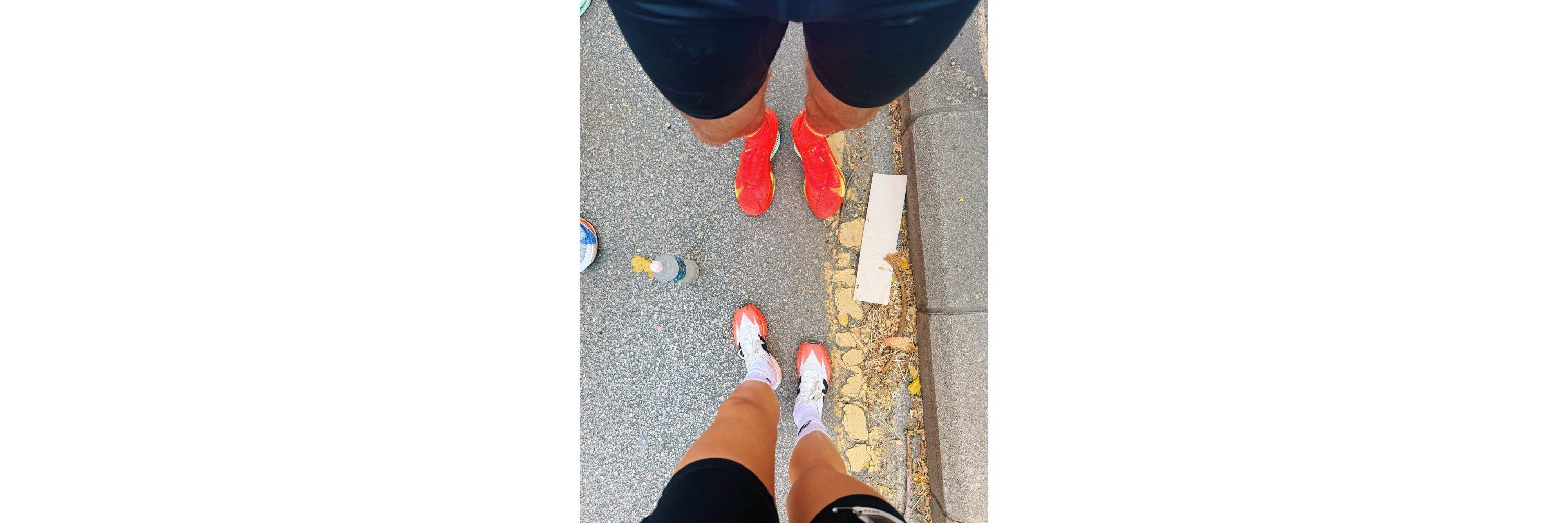 A picture looking towards the shoes of two people wearing running clothing 