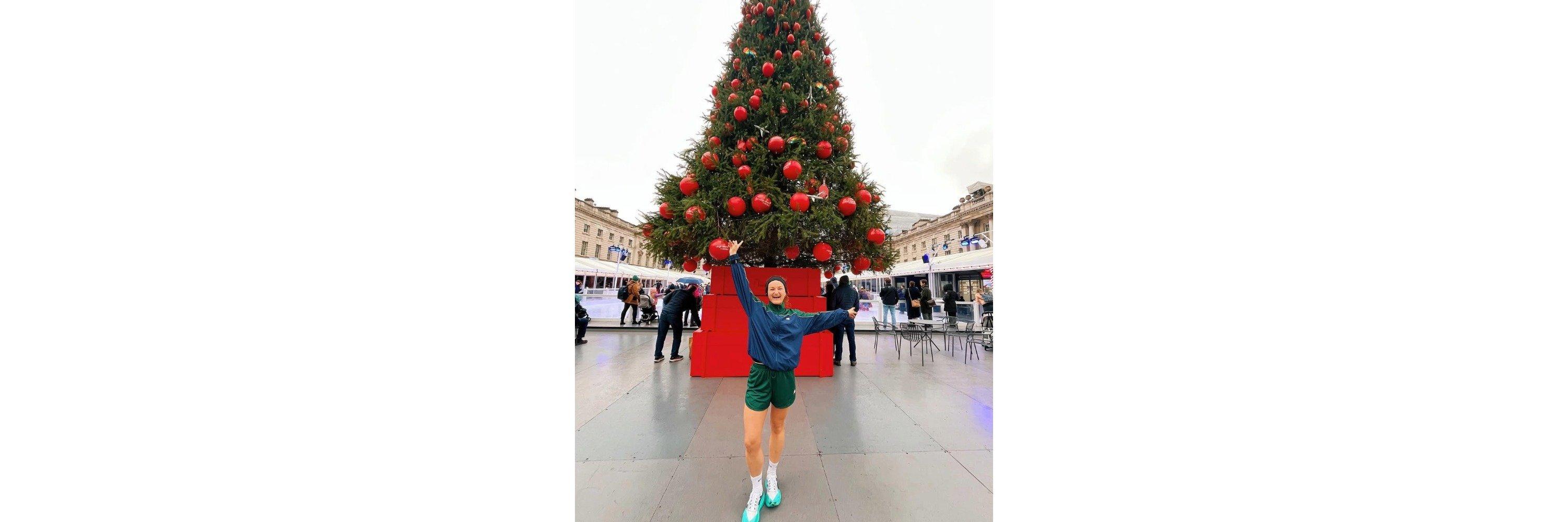 Ally Head stood in front on a Christmas tree