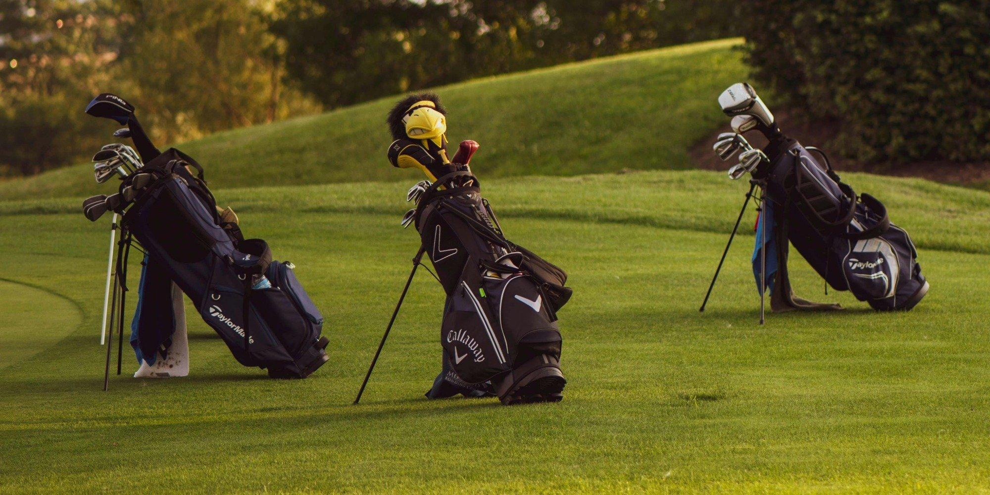 Three golf bags on a golf course