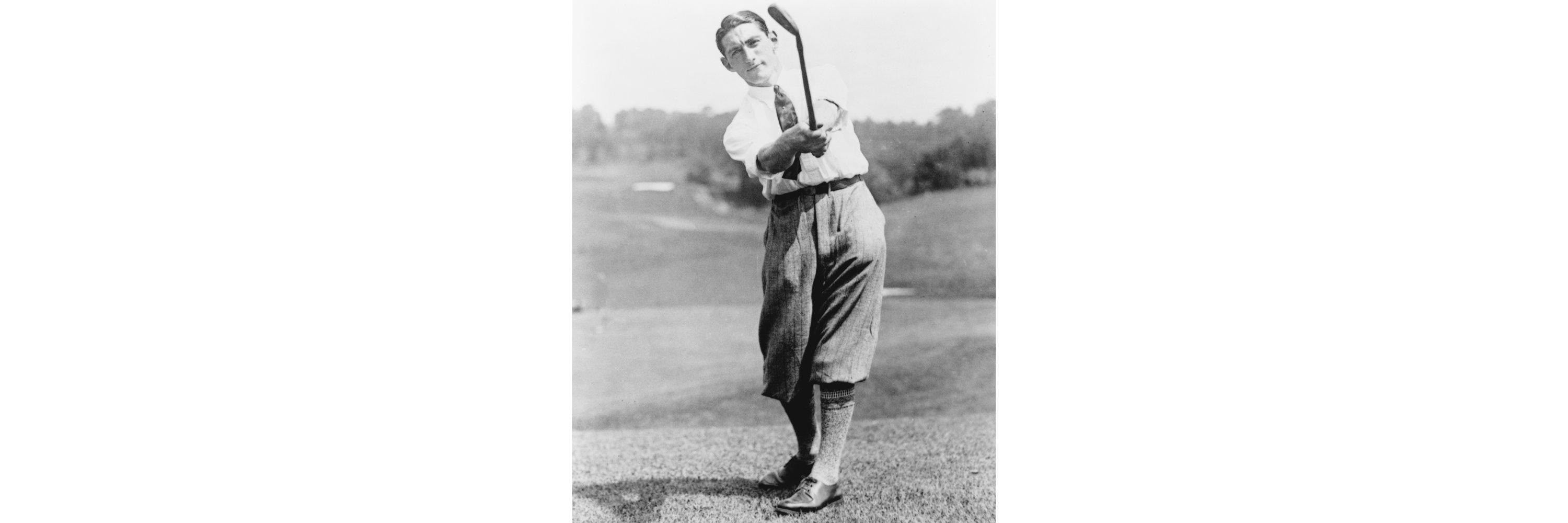 A man wearing golf attire swinging a golf club
