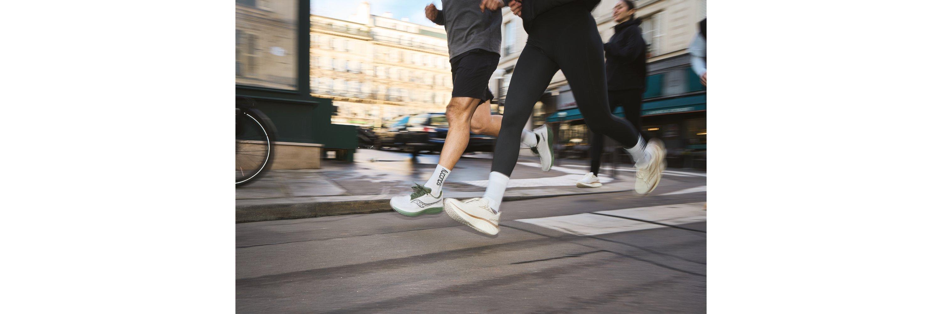 Two people running side by side on the road in running gear