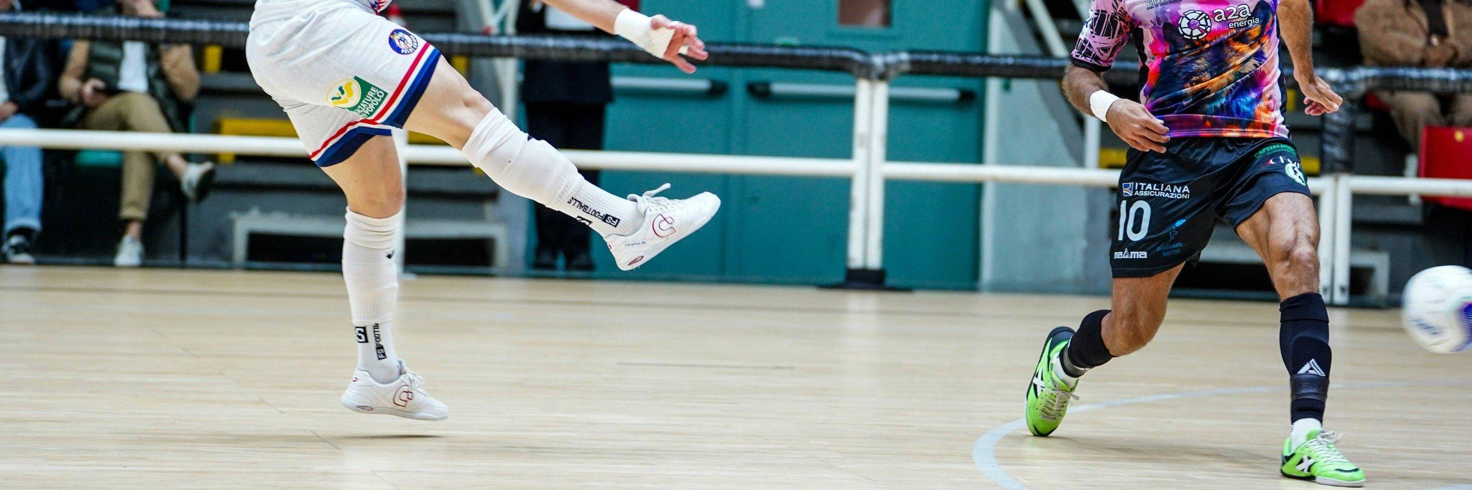 Two players competing on an indoor football court