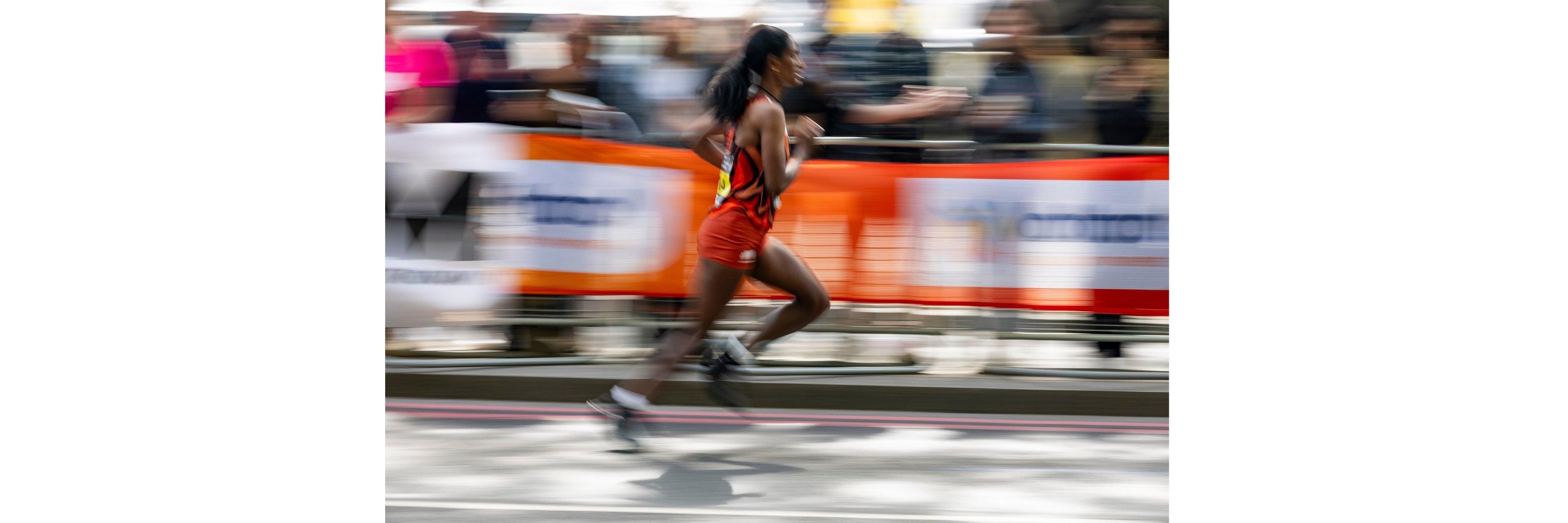 A picture of a women wearing running clothes running in the london marathon