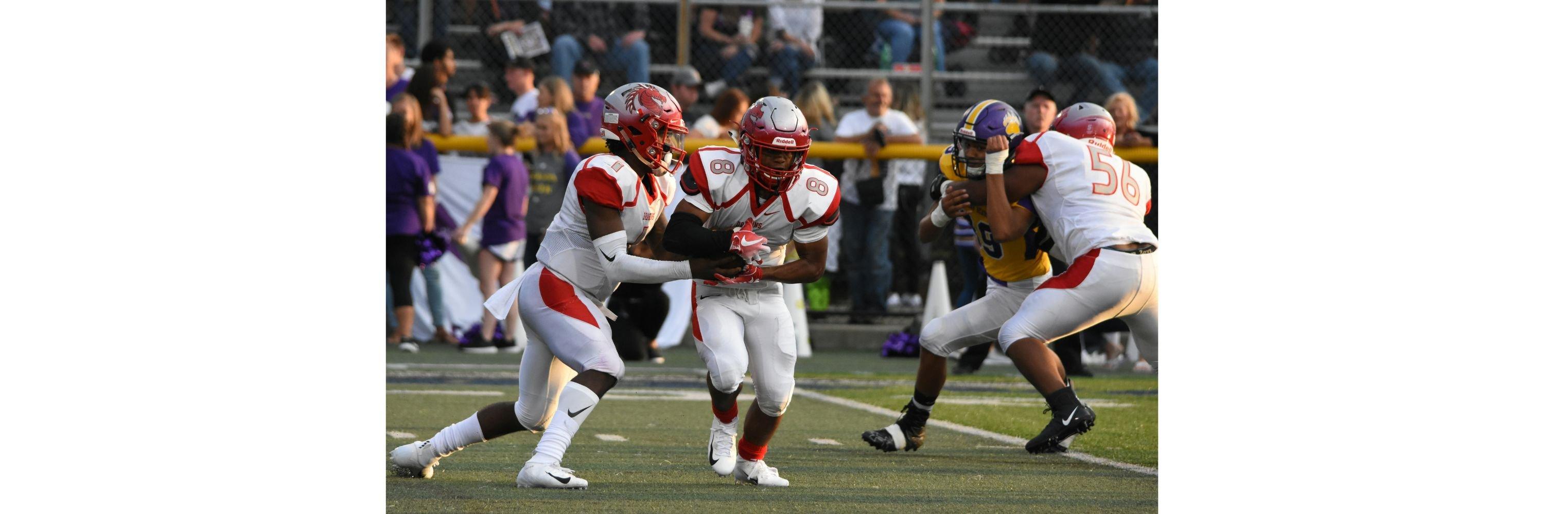 An American Football player being handed the ball during a game