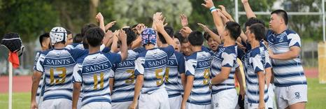 Standing in a huddle, rugby players having a team talk before a game