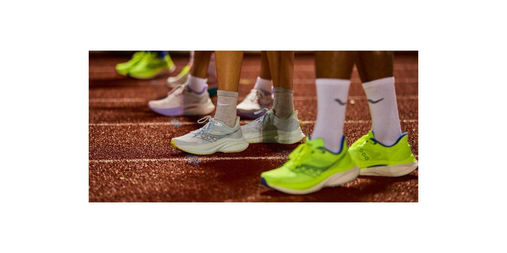 People wearing running shoes, standing in a line on a track