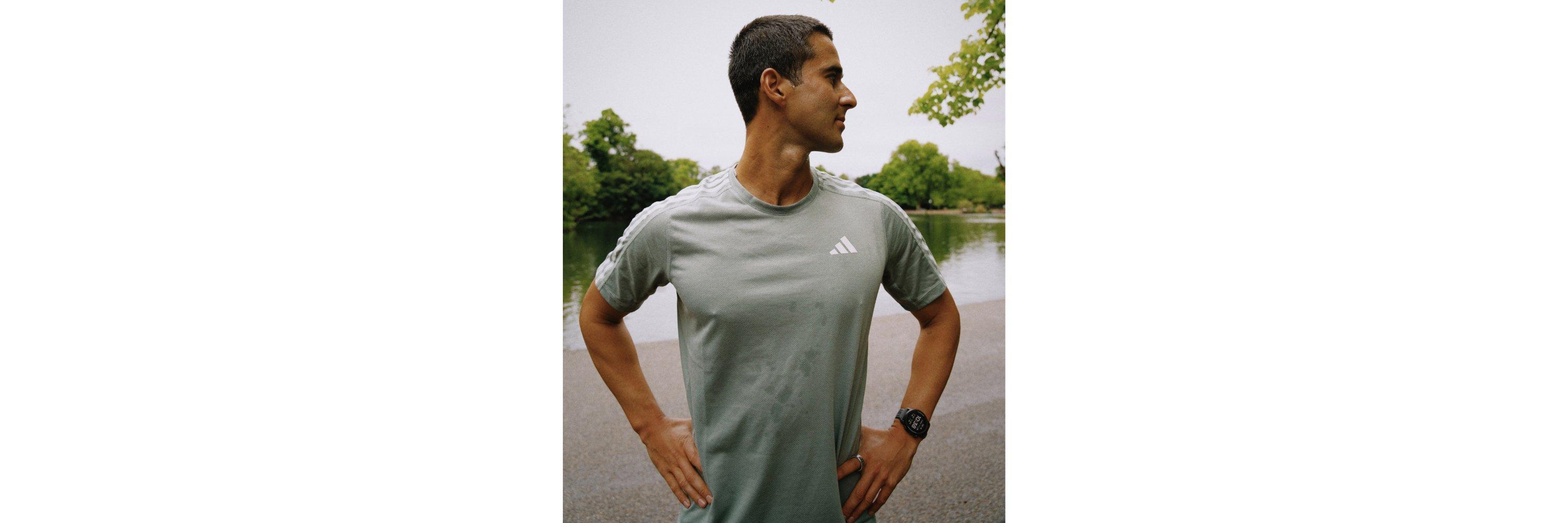 Man in running clothes stood with his hands on his hips