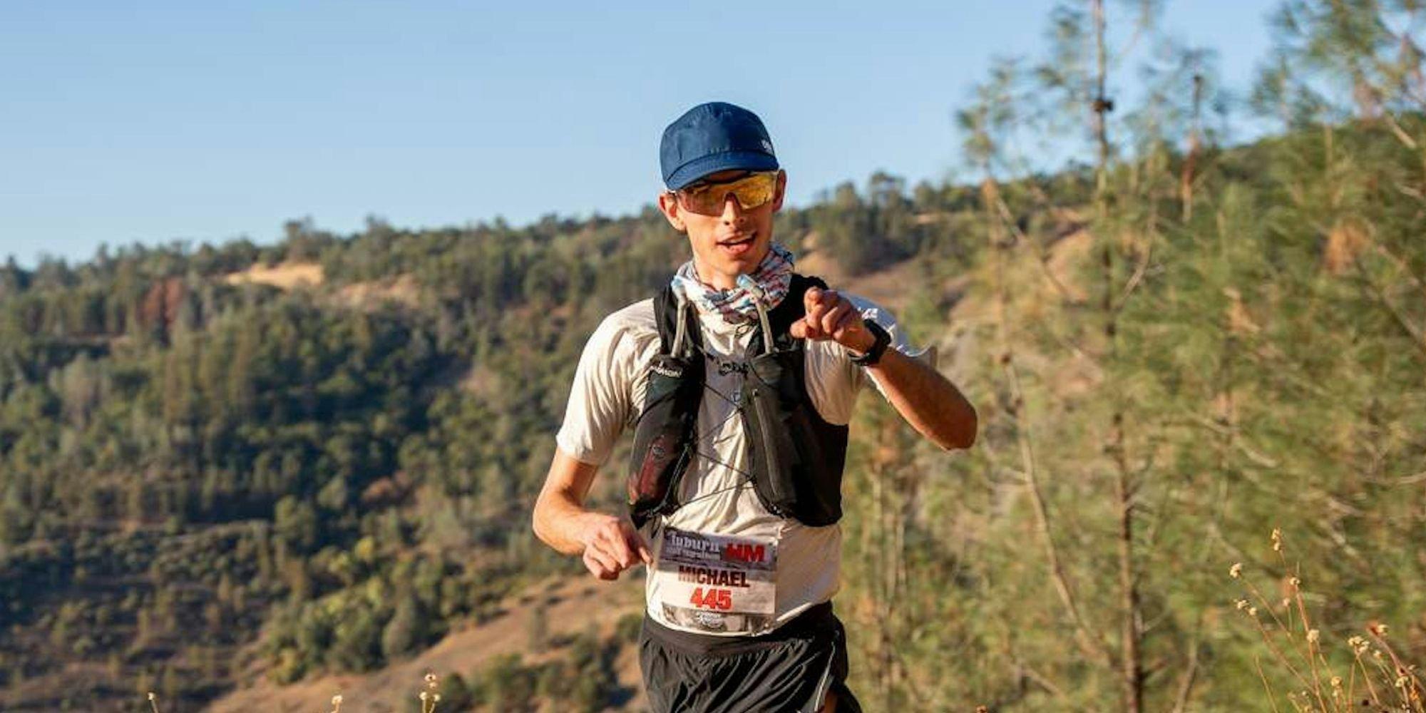 Man running through long grass wearing running gear