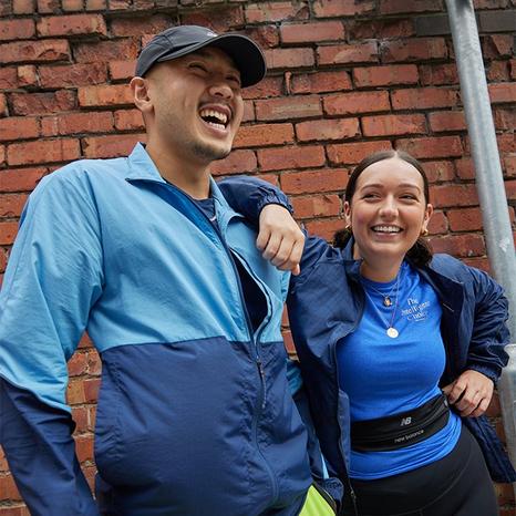 Par sjedi uz rub ceste u opremi za trčanje New Balance