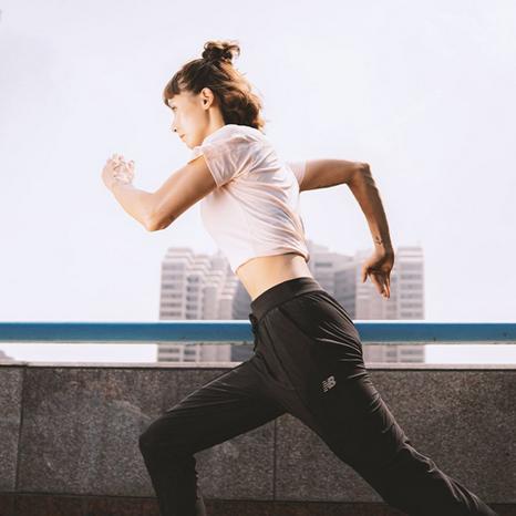 Donna che corre per strada con abbigliamento da corsa New Balance.