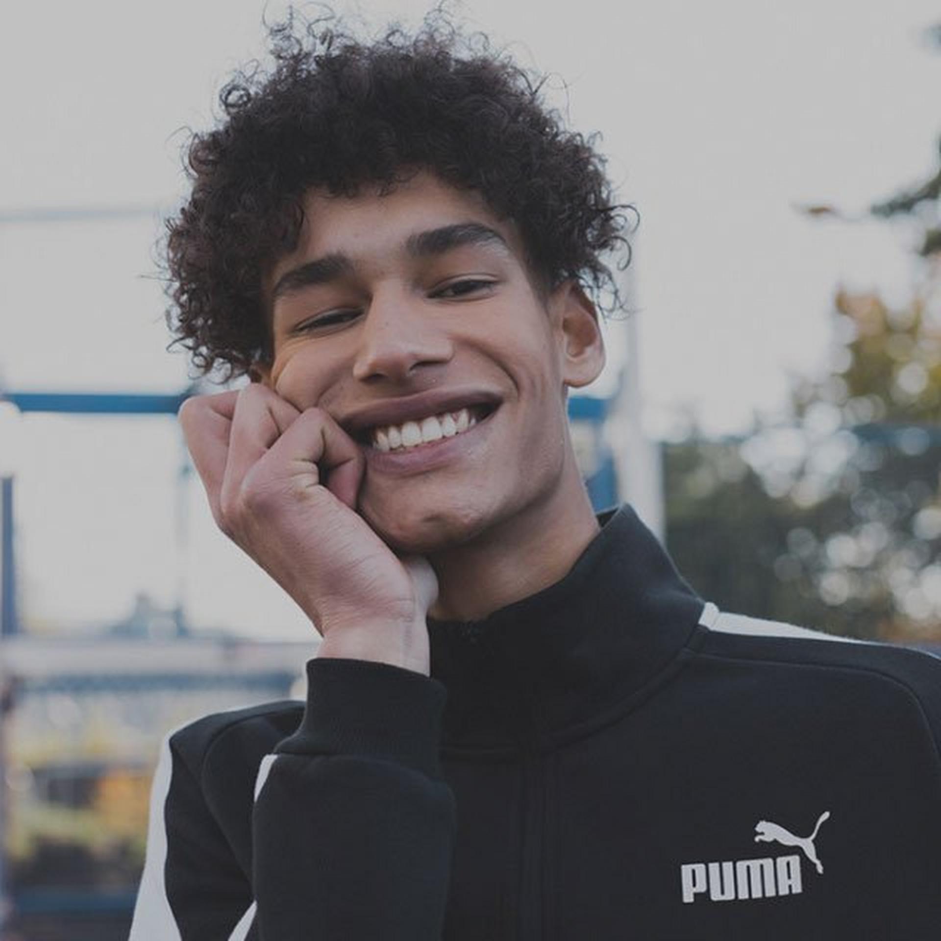 Man smiling at the camera in a Puma tracksuit