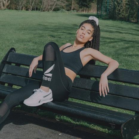 Woman posing on a parkbench in Reebok trainingwear