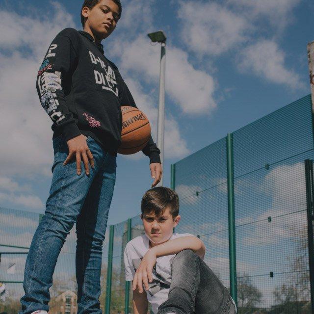 Kids posing with a basketball in Reebok clothes