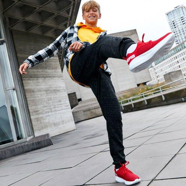 Kid kicking the air in Skechers Shoes