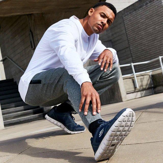 Man posing with Skechers sneakers on