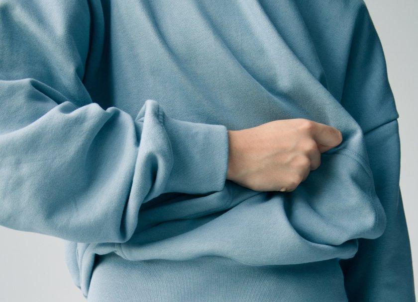 hand feeling blue sweatshirt on figure