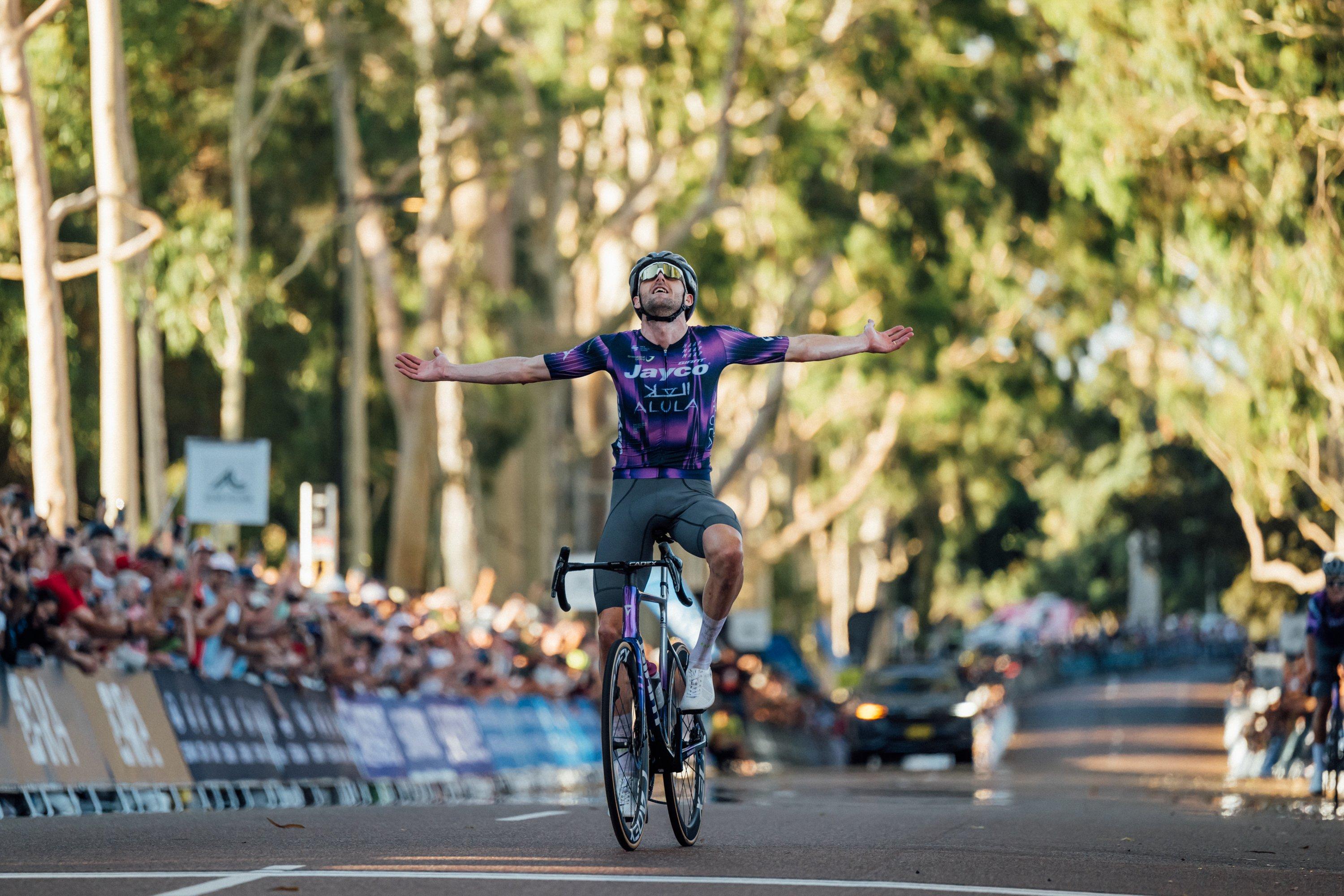 a man on a bike with his arms outstretched in the air