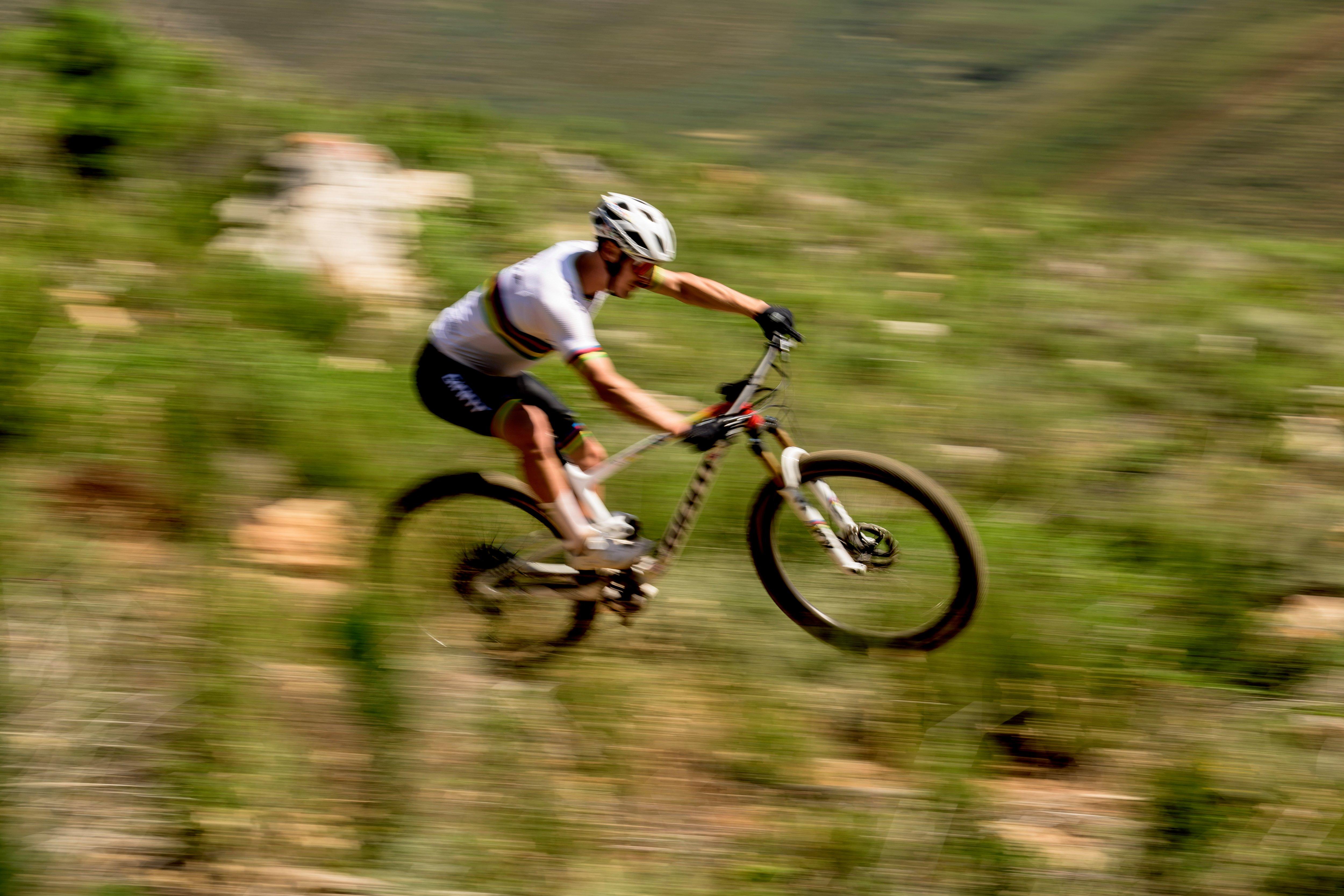 a man riding a mountain bike on a grassy hill