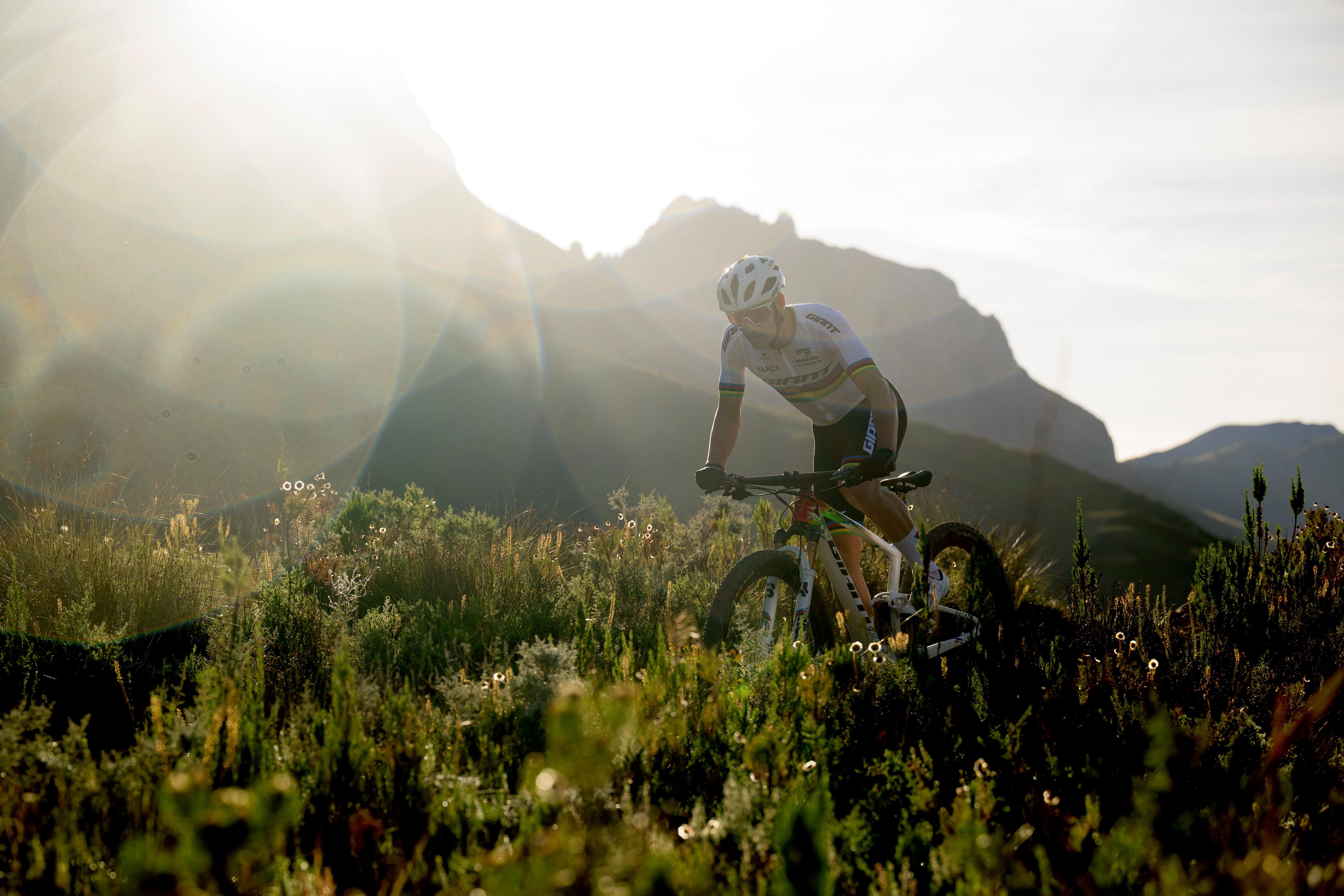 a man riding a mountain bike through a field of tall grass