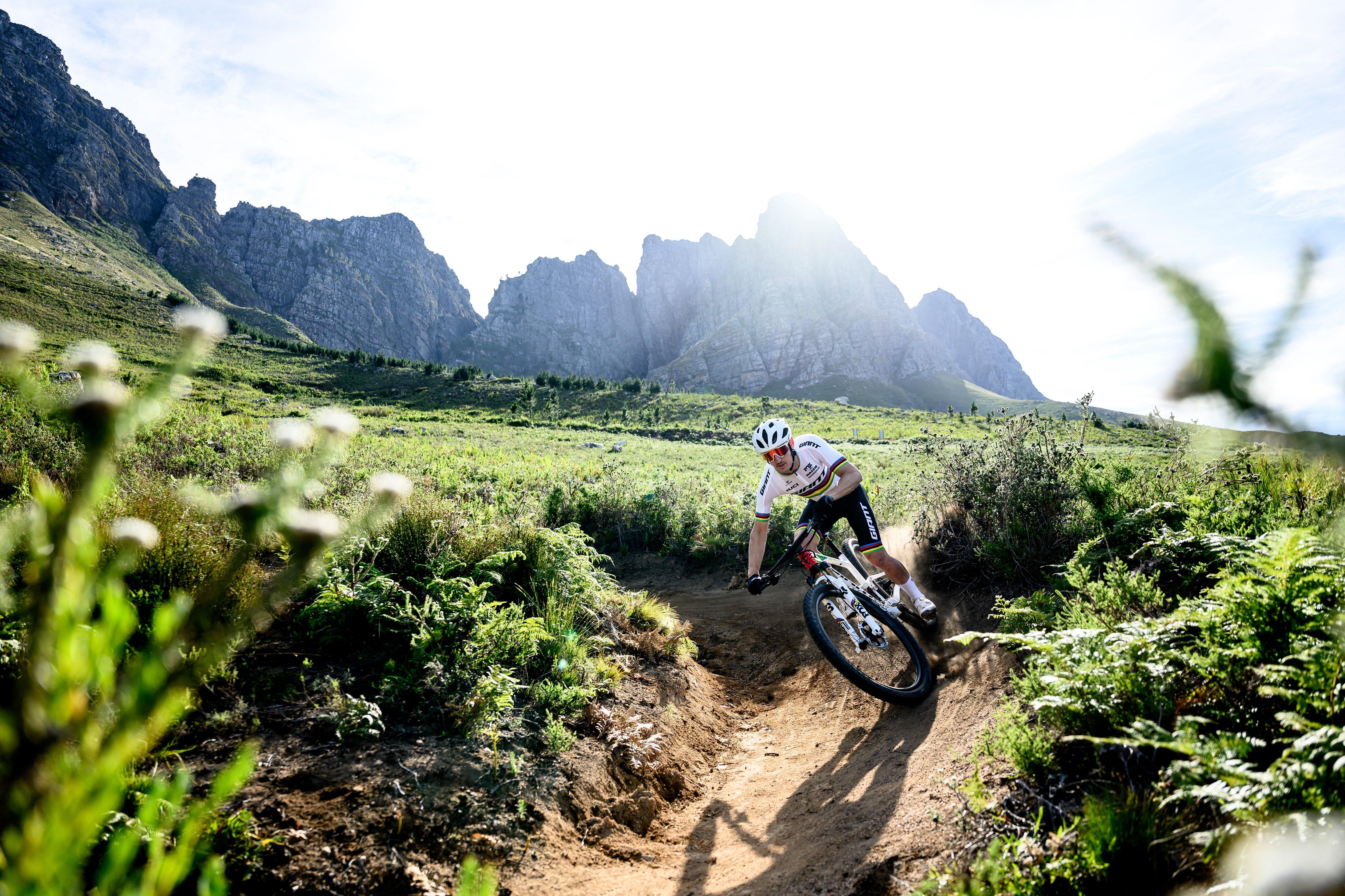 a man riding a mountain bike on a trail in the mountains