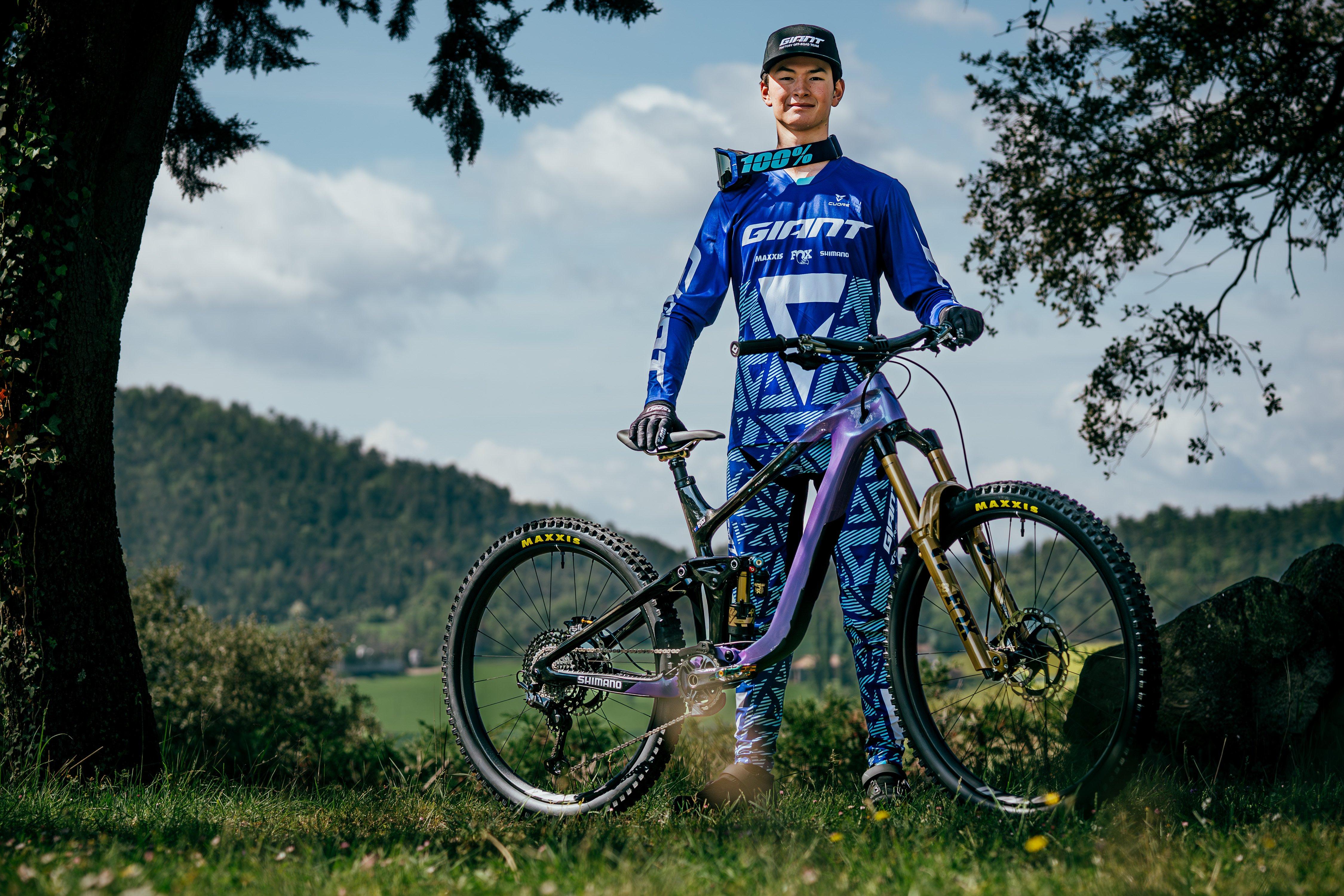 a man in blue and white riding a mountain bike in the grass