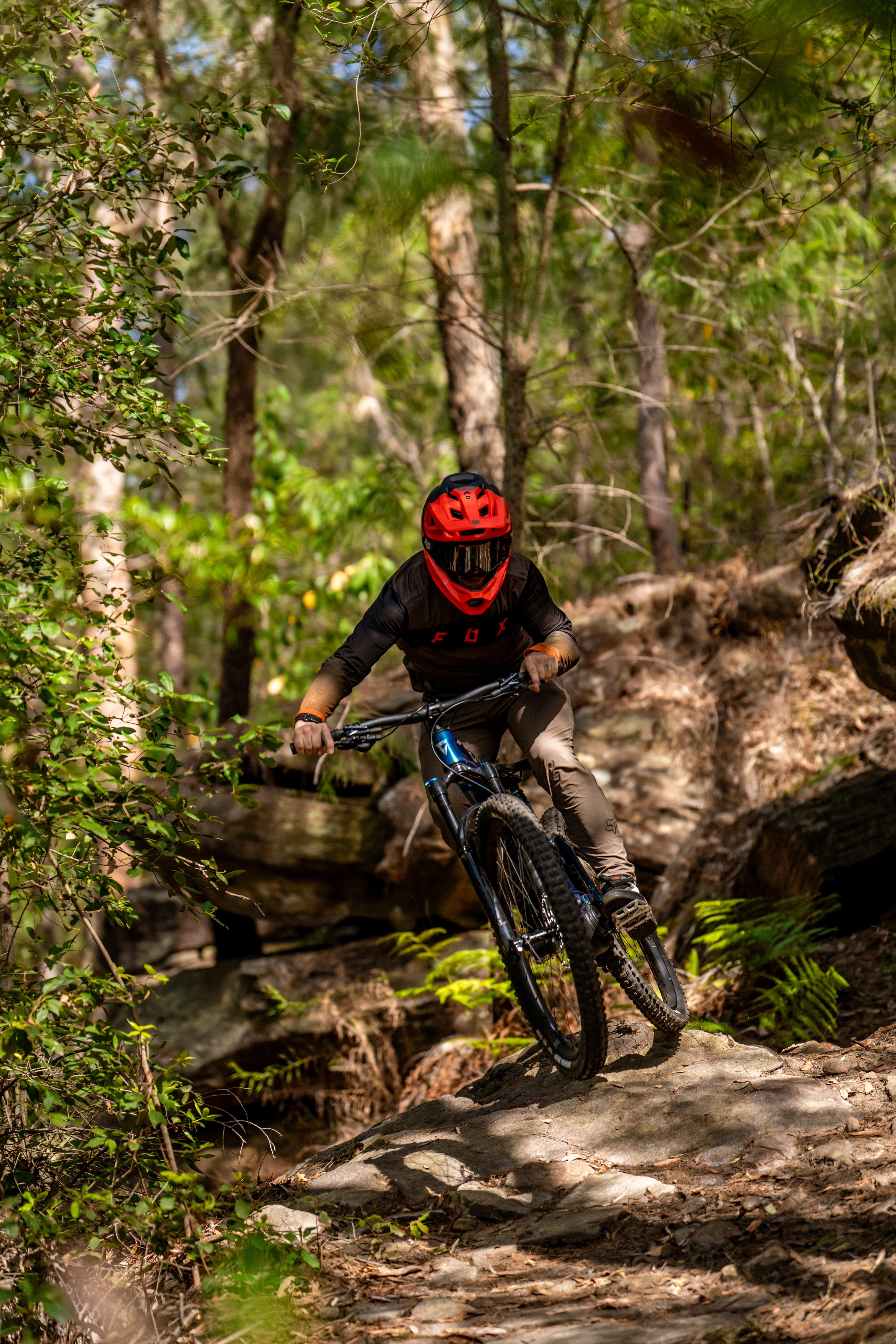 a person riding a mountain bike on a trail in the woods