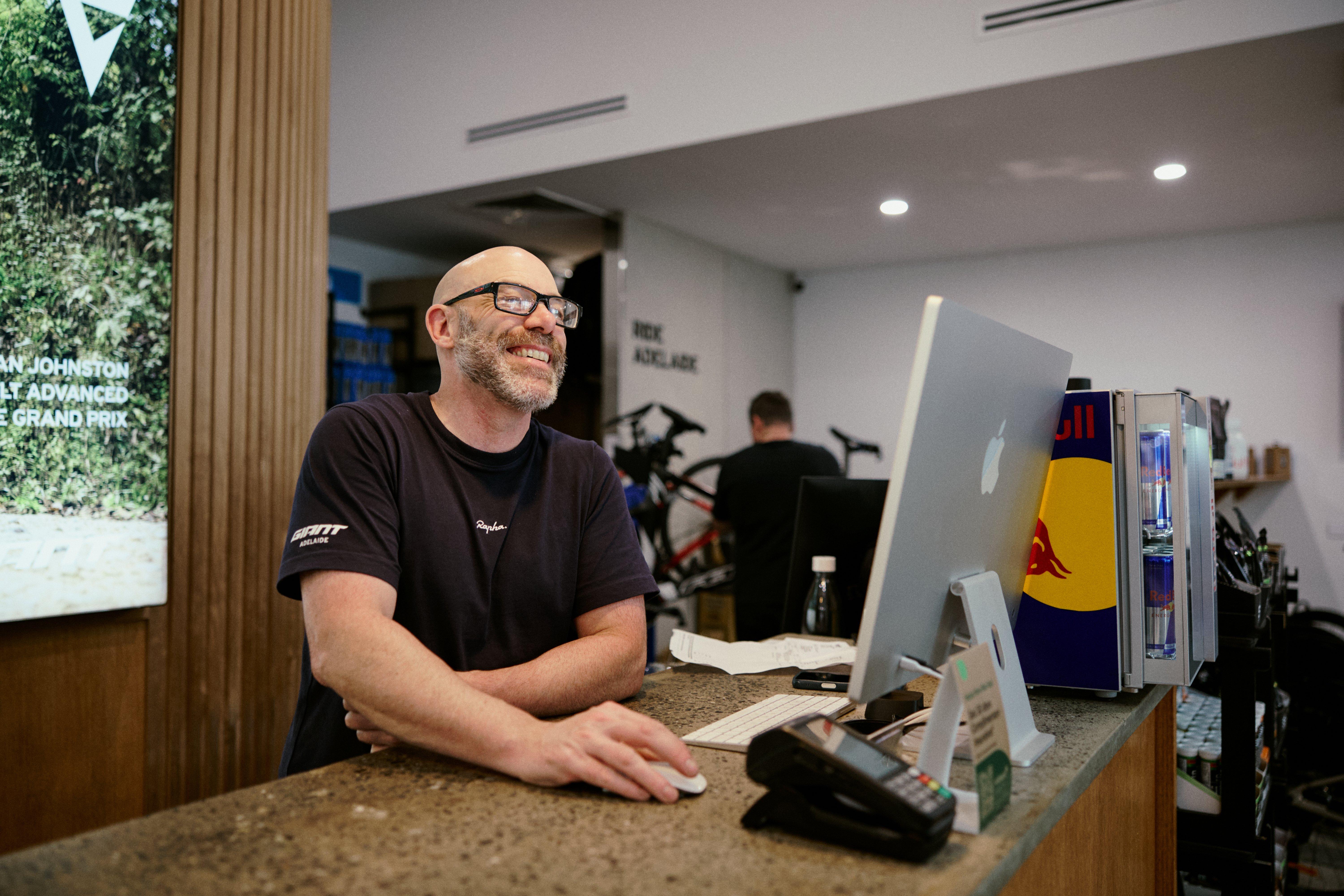 a man standing in a bike shop with a bunch of bikes