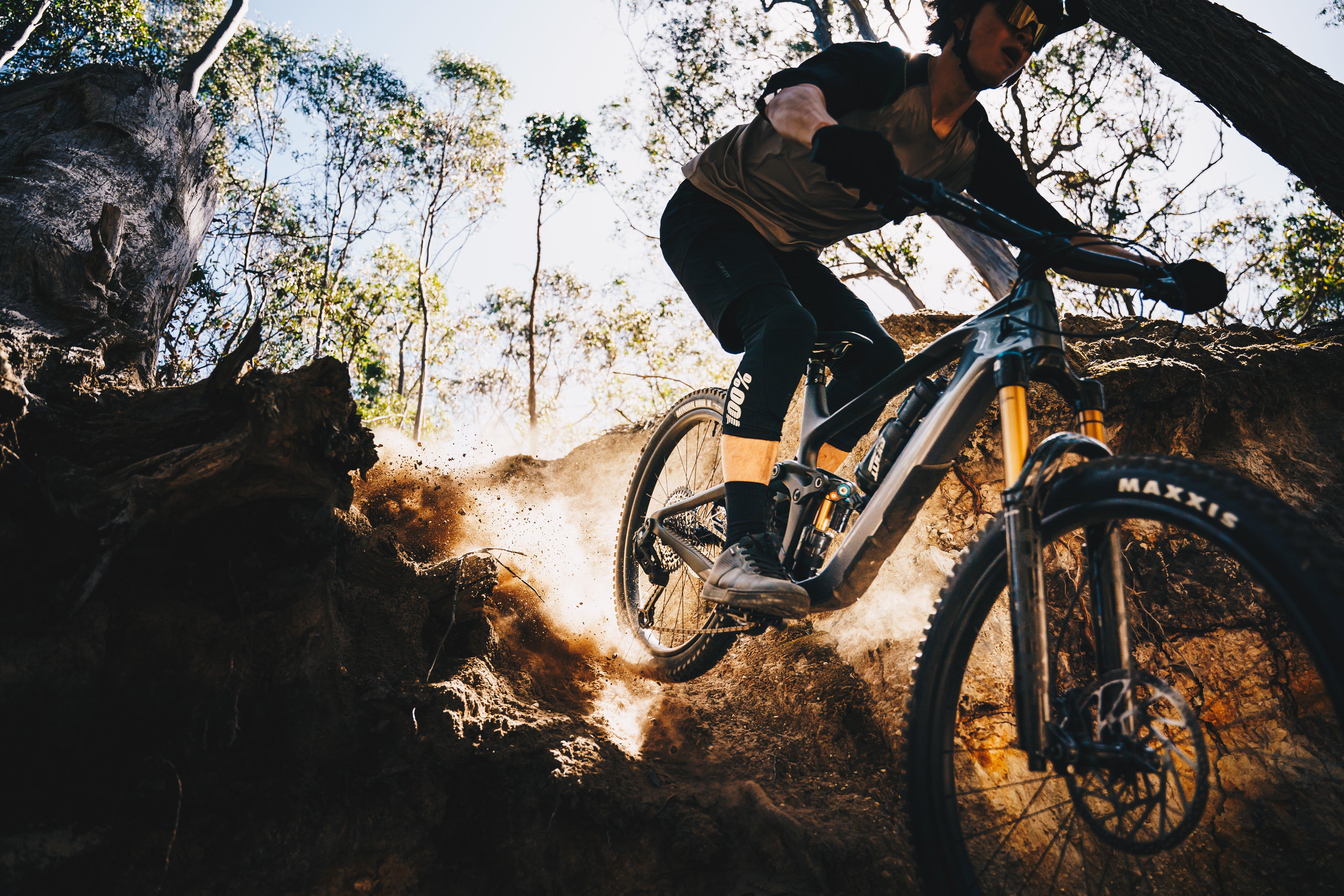 a mountain biker is riding down a rocky trail