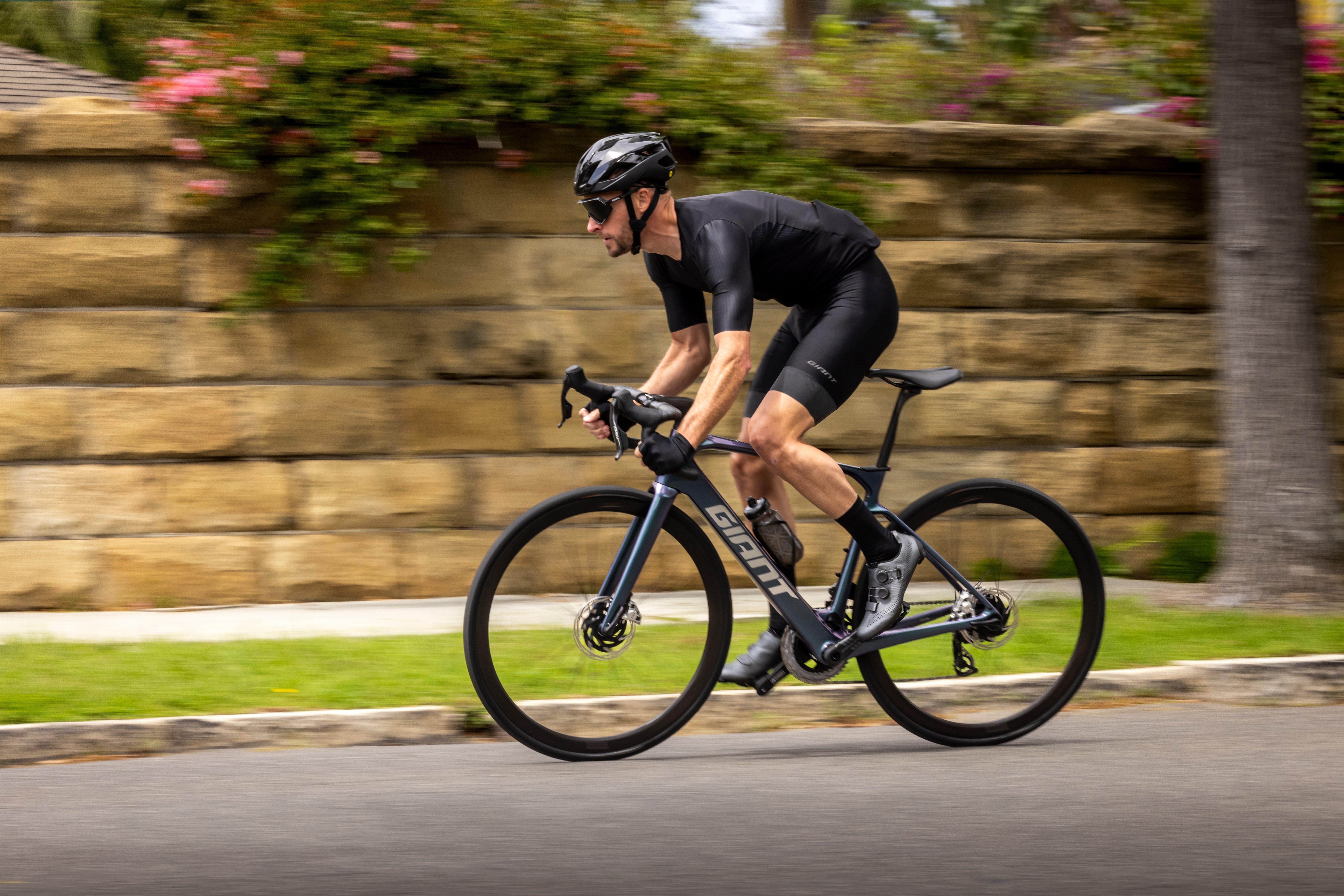 a man riding a bike down a street in a black shirt