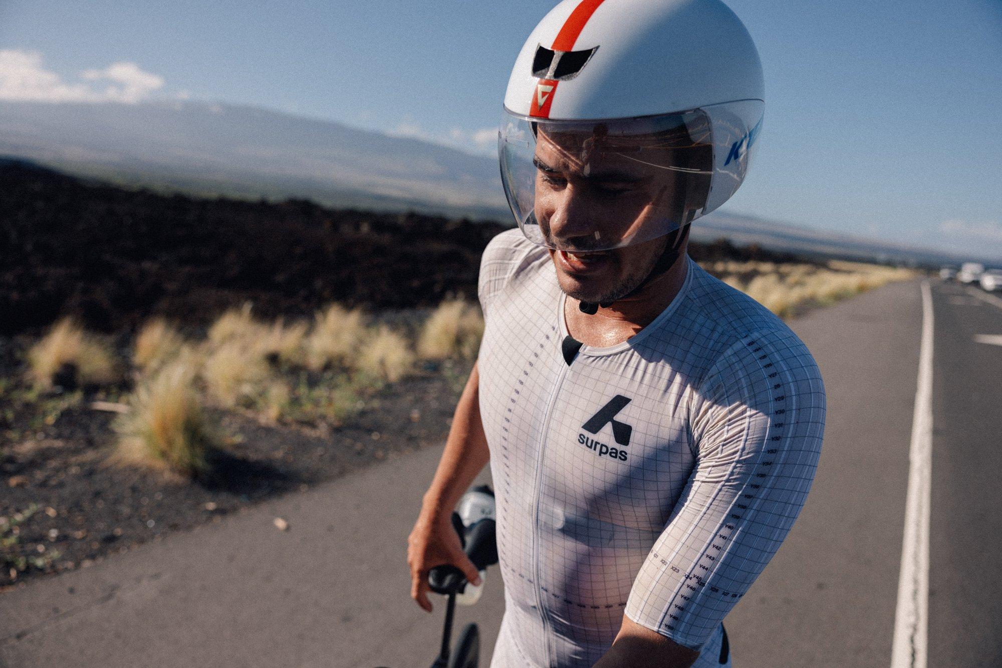 a man in a helmet and white shirt riding a bike