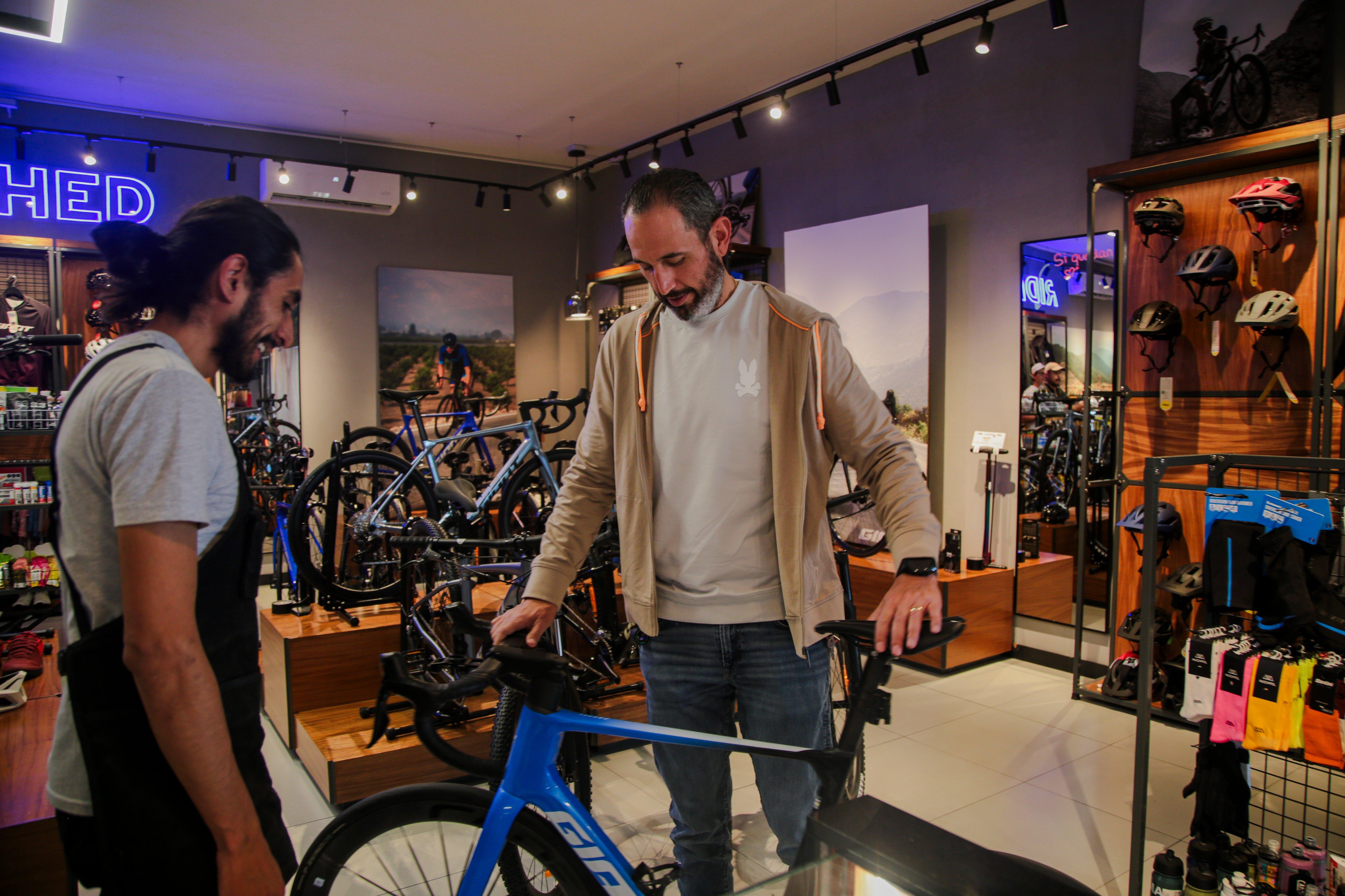 a man and a woman in a bike shop looking at a bike