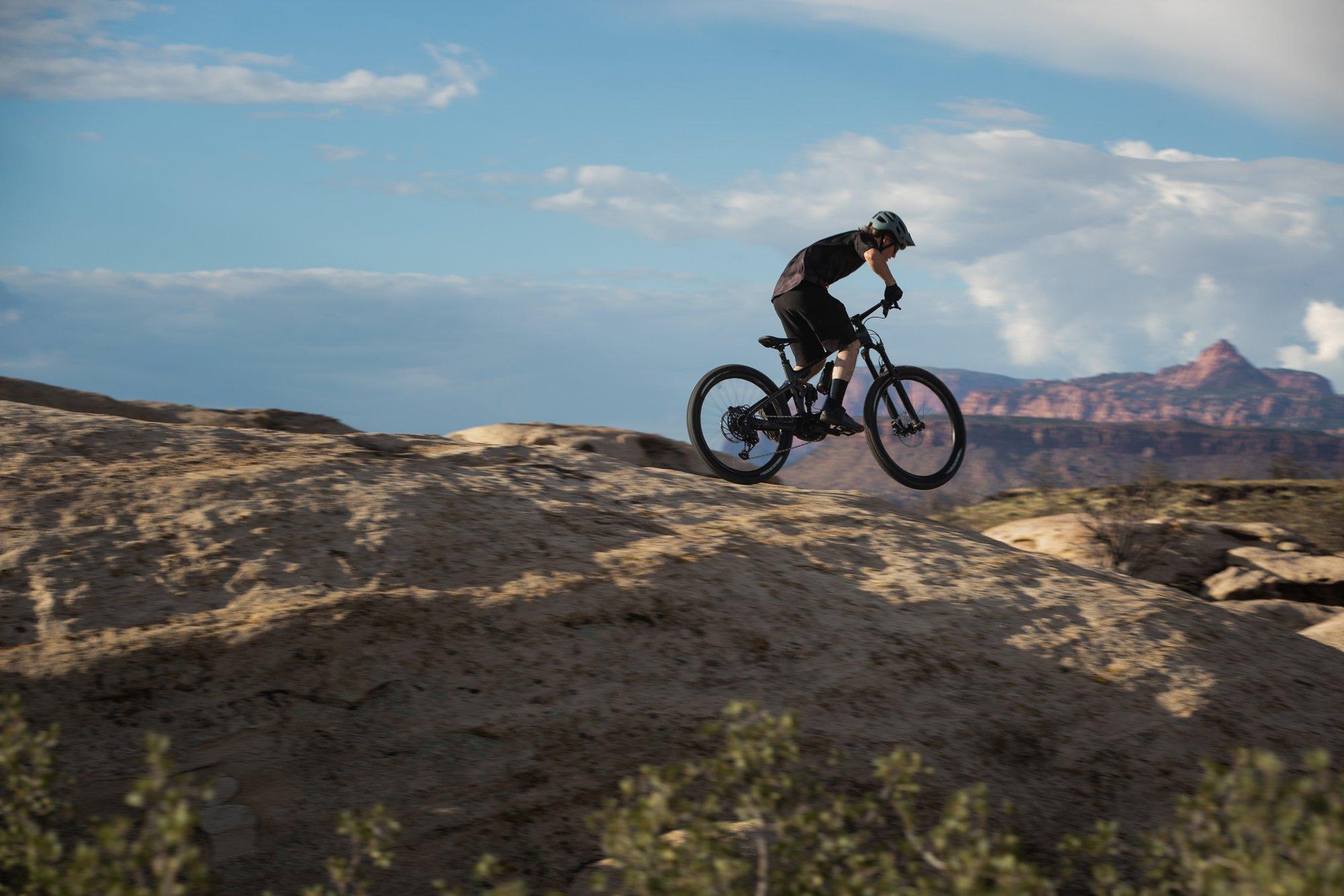 a man riding a mountain bike on a rocky hill