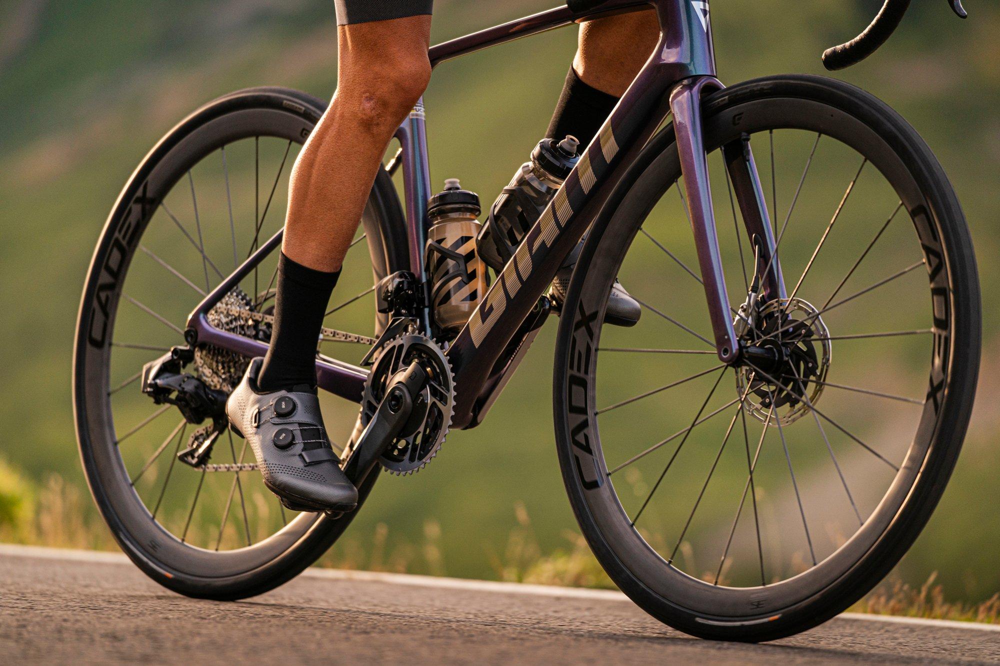 a man riding a purple bike down a road
