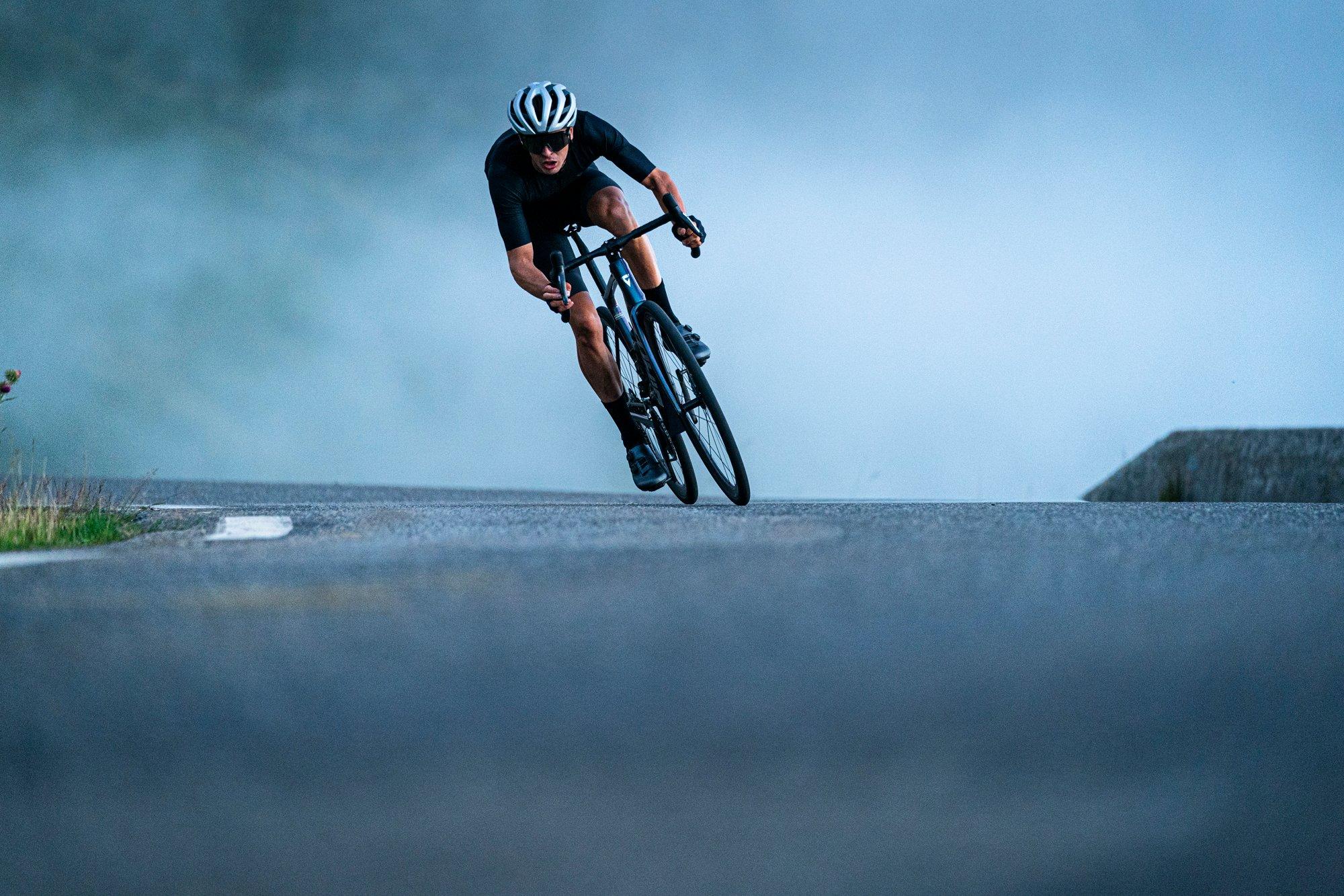 a cyclist riding down a road in the fog
