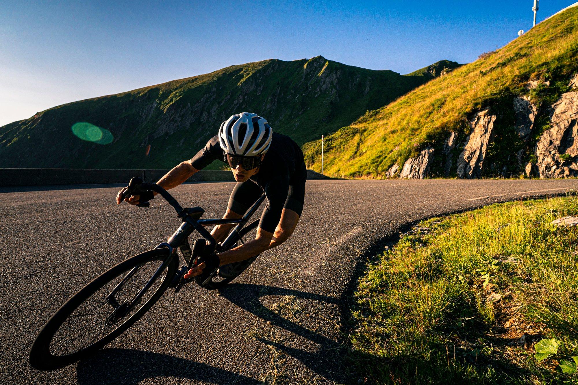 a man riding a bike down a curvy road in the mountains