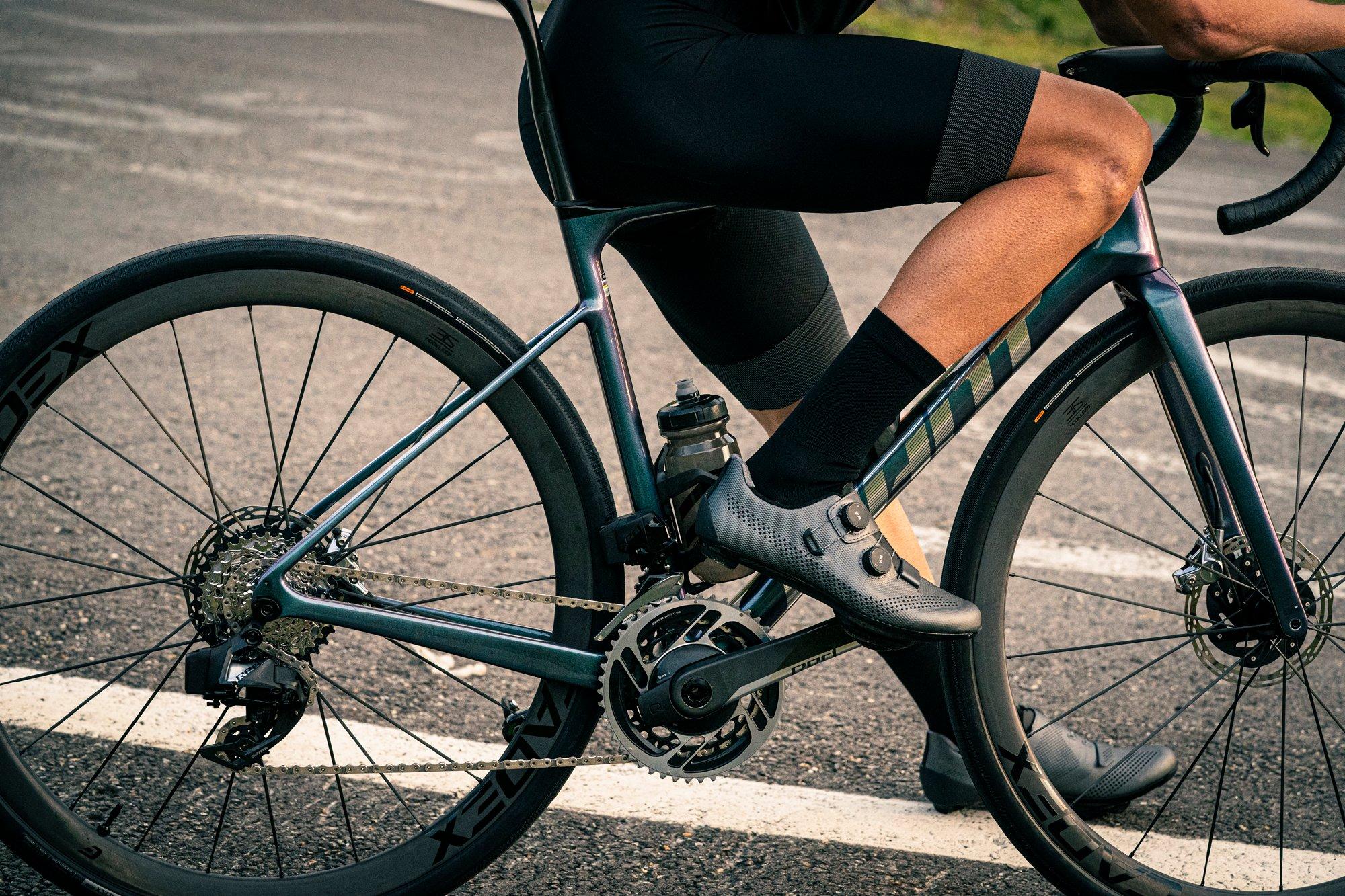 a man in black riding a bike on a street