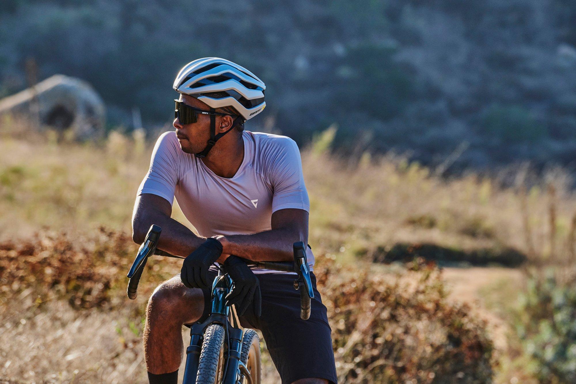 a man riding a bike on a dirt road in the mountains