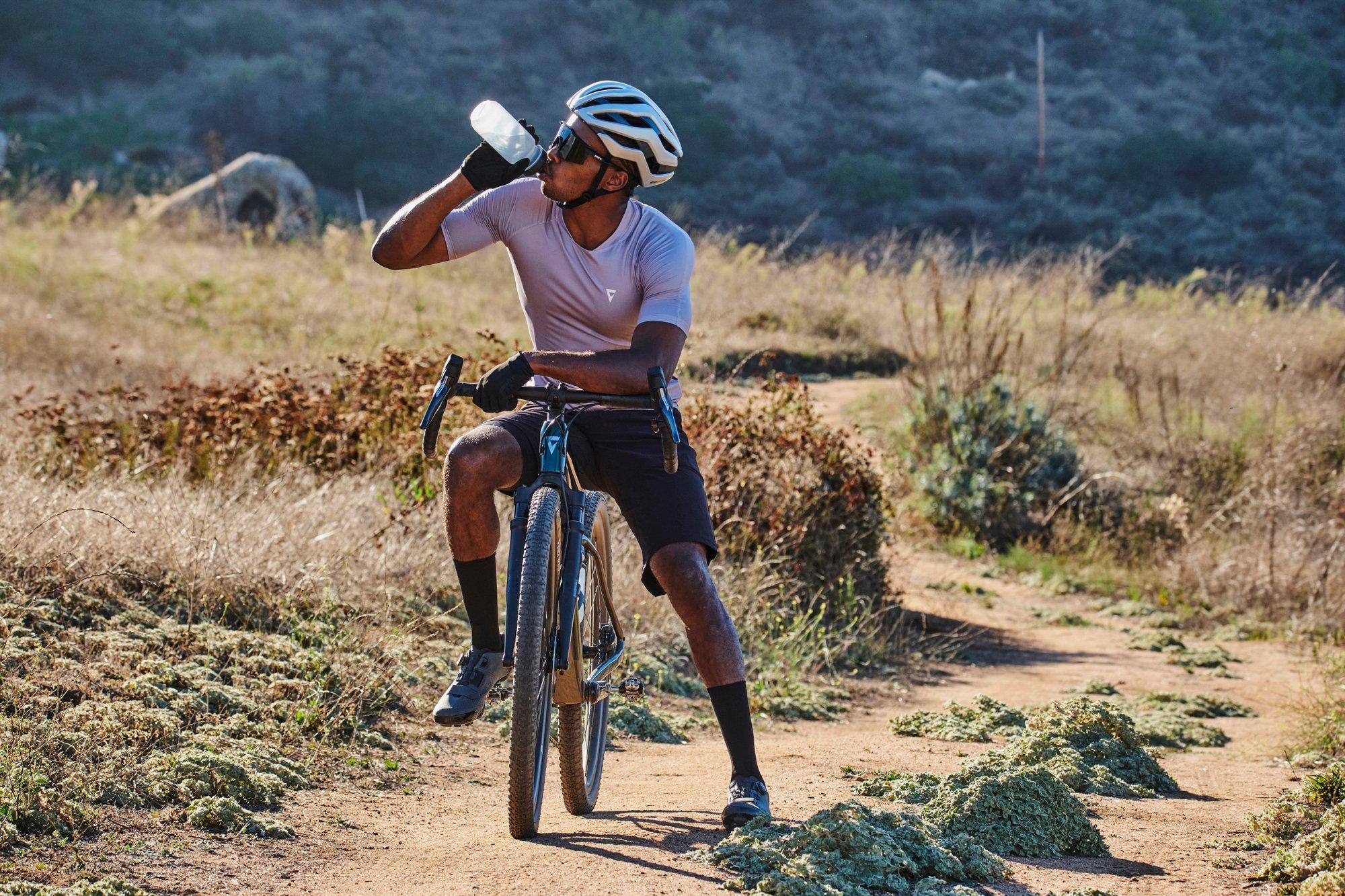 a man riding a bike on a dirt road with a helmet on