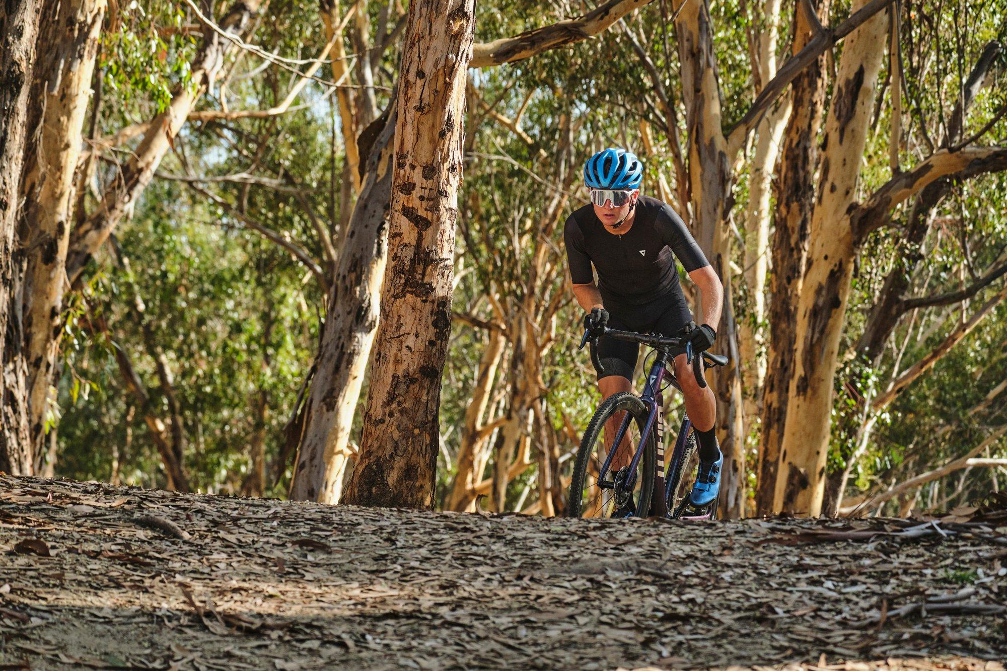 a man riding a bike on a trail in the woods