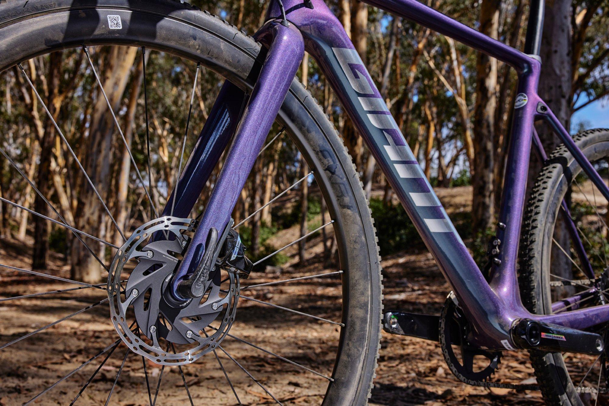 a purple bicycle is parked in the woods
