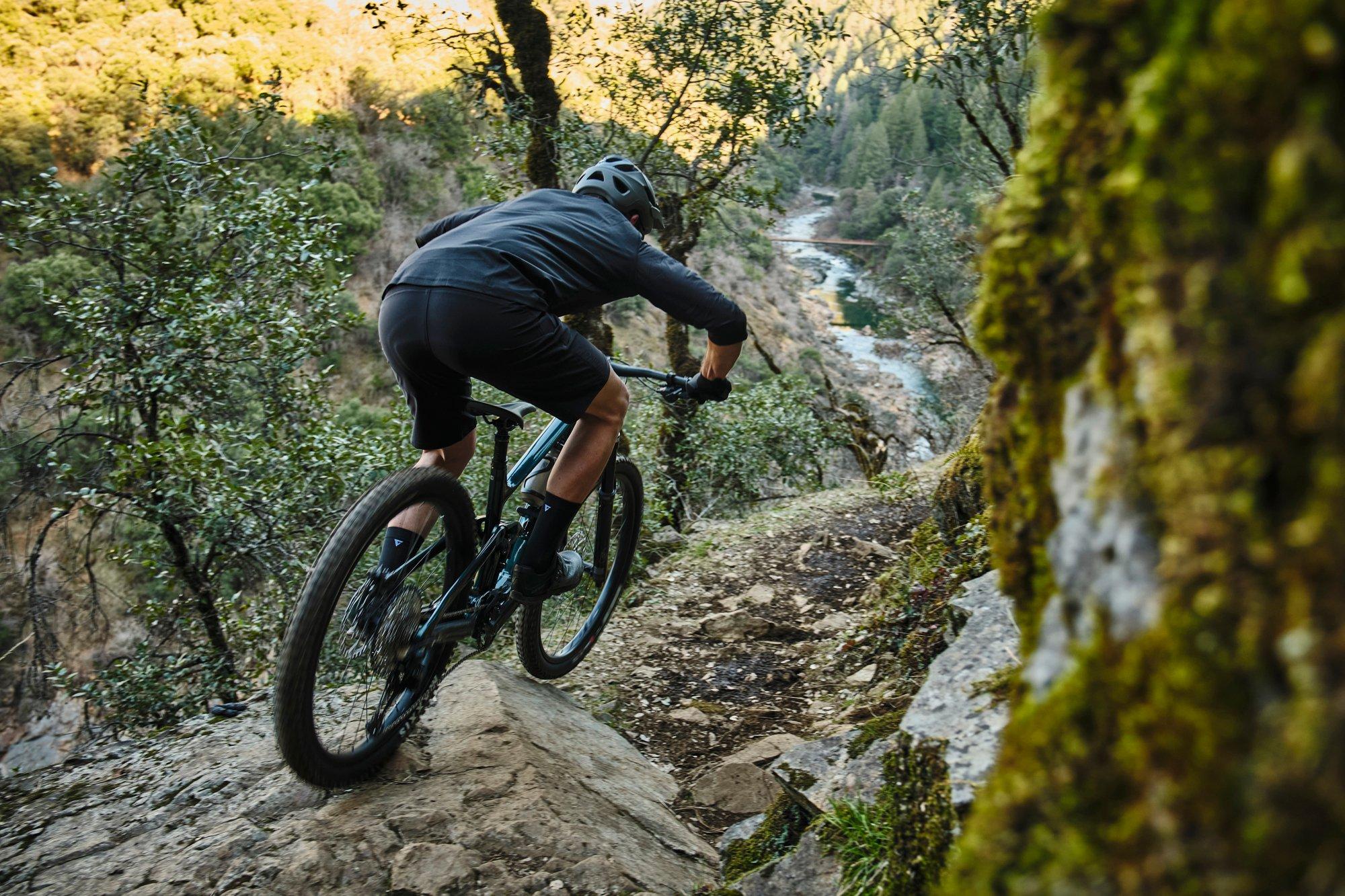 a man riding a mountain bike down a rocky trail