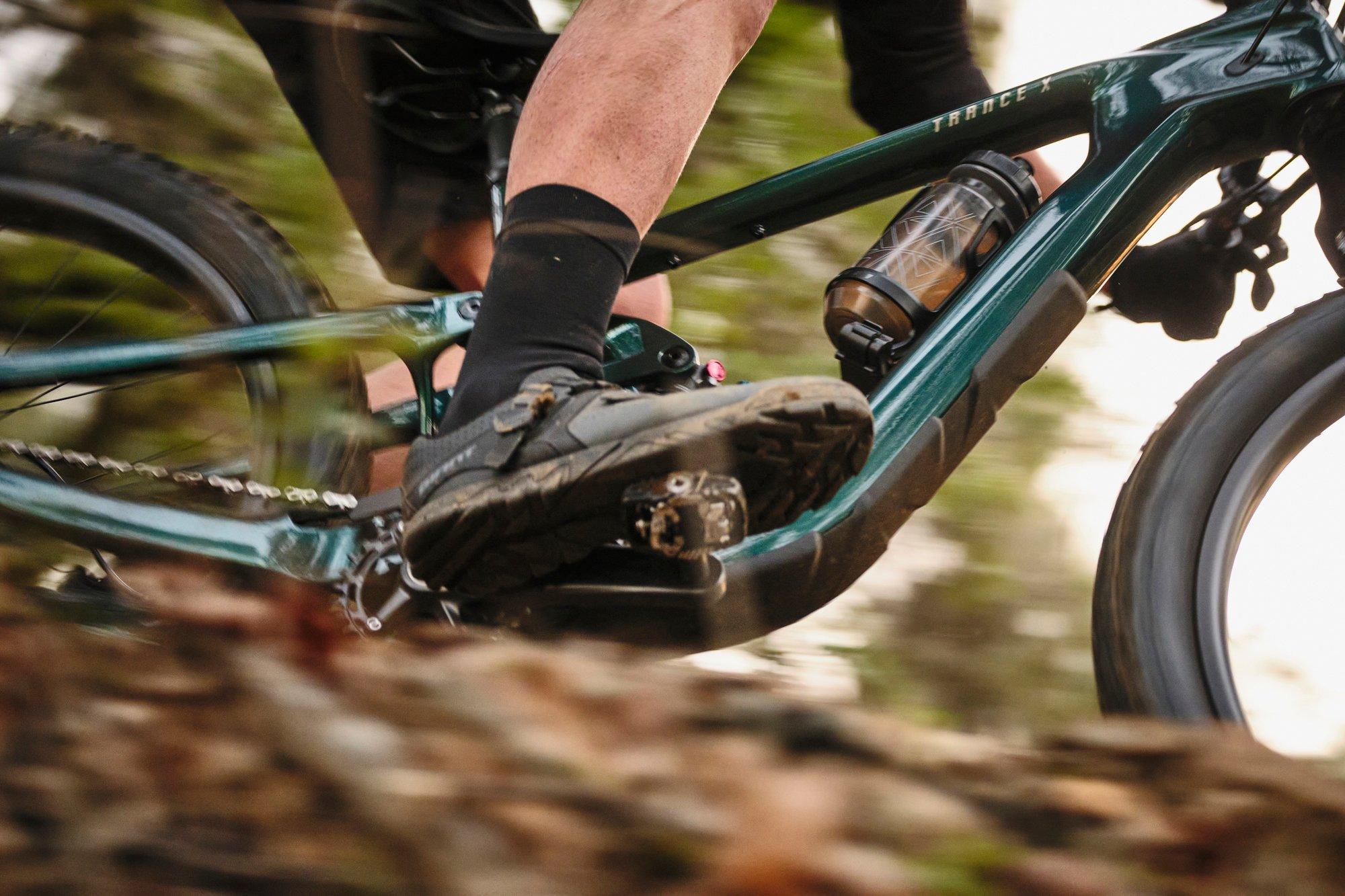a close up of a person riding a mountain bike on a trail
