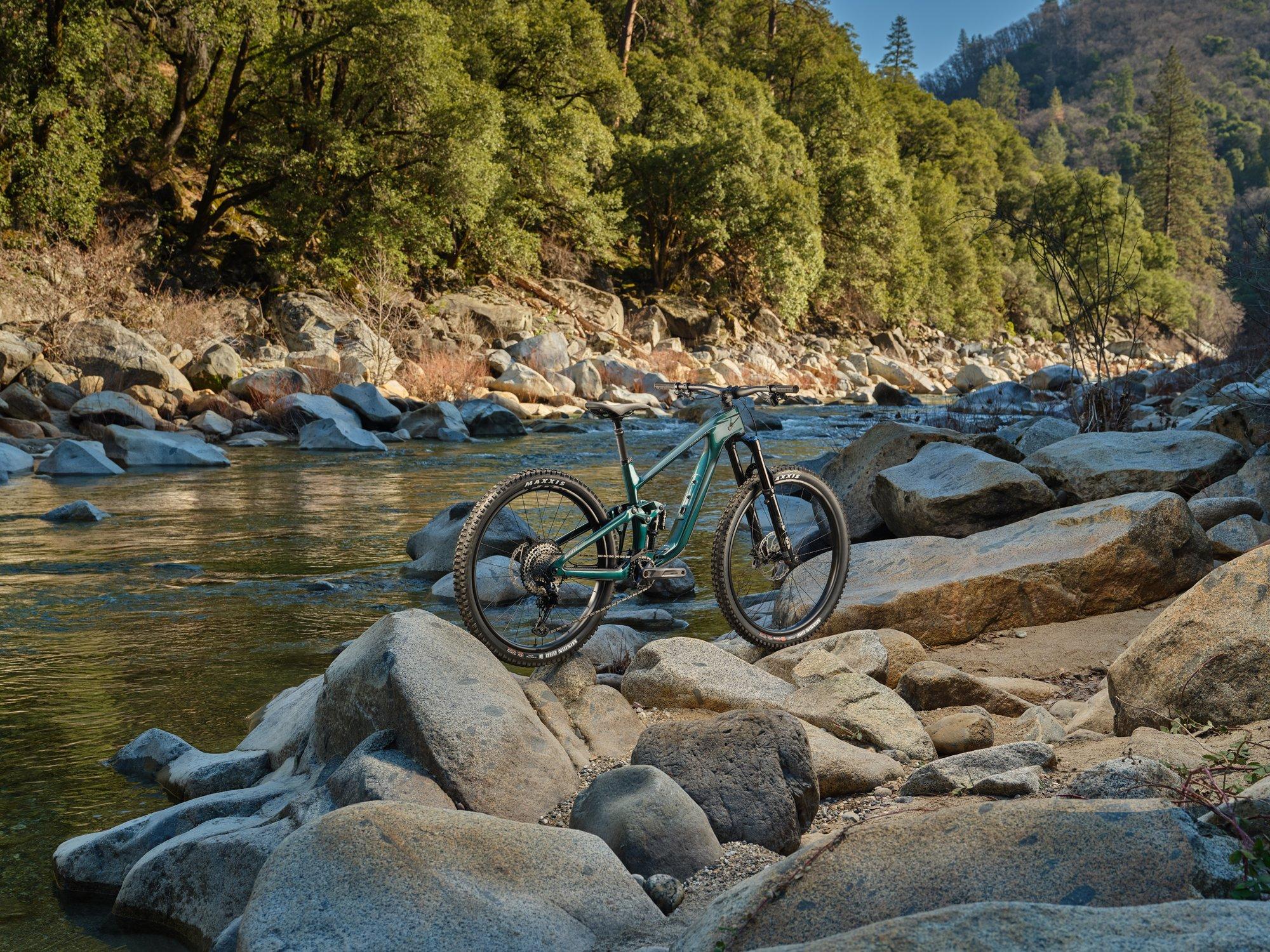 a mountain bike is parked on a rock by a river