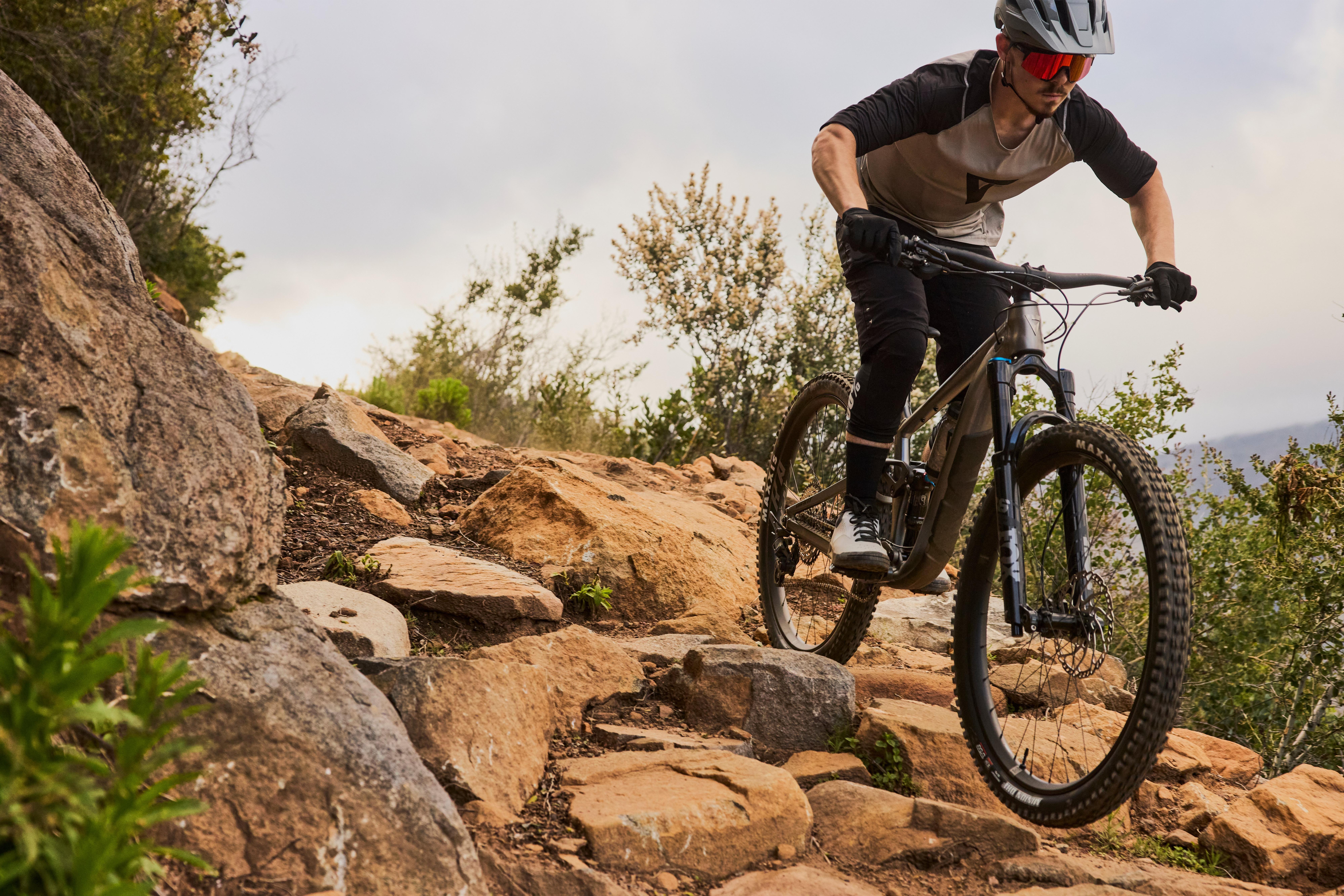a man riding a mountain bike on a rocky trail