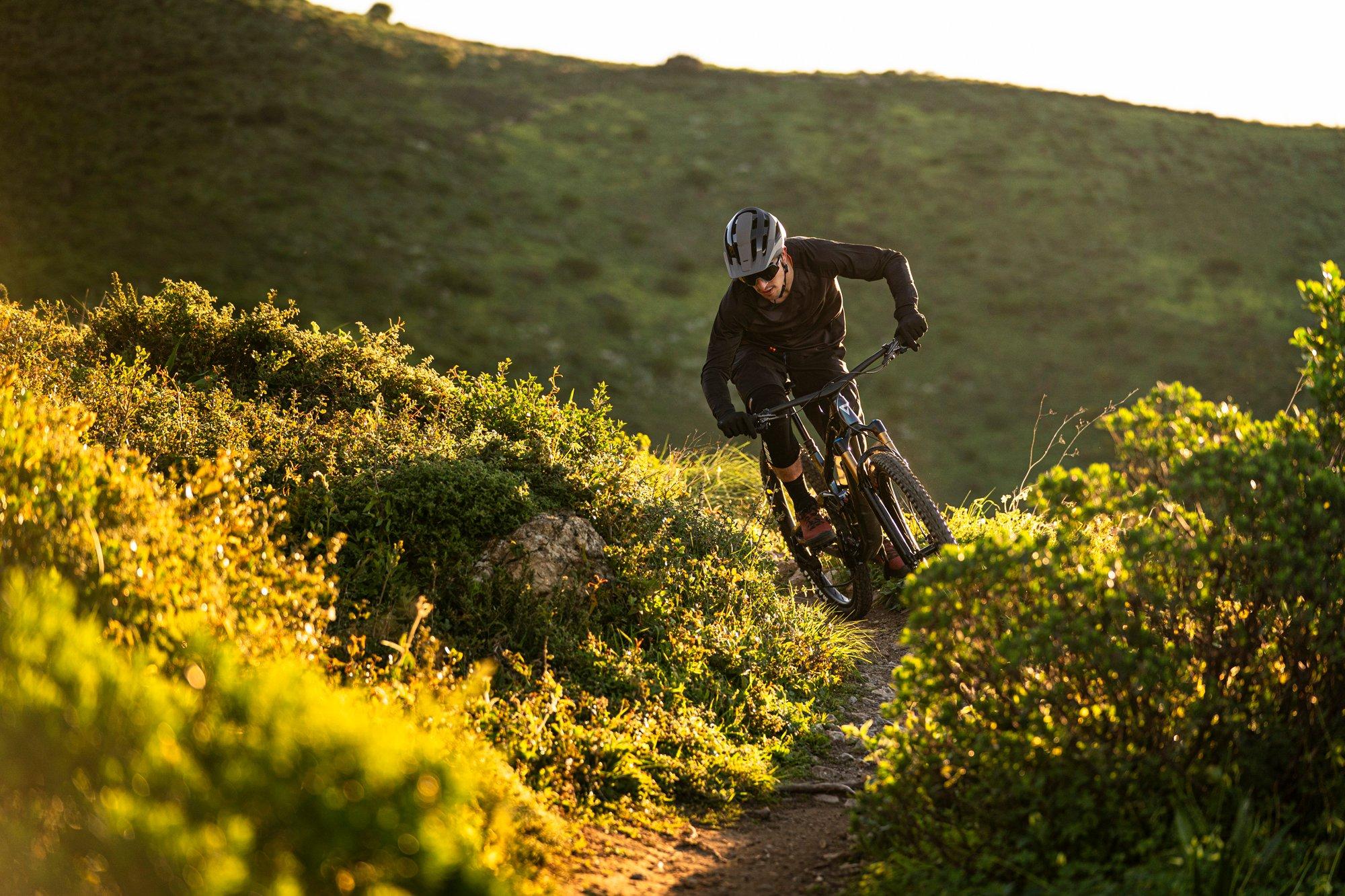 a mountain biker rides down a trail in the mountains