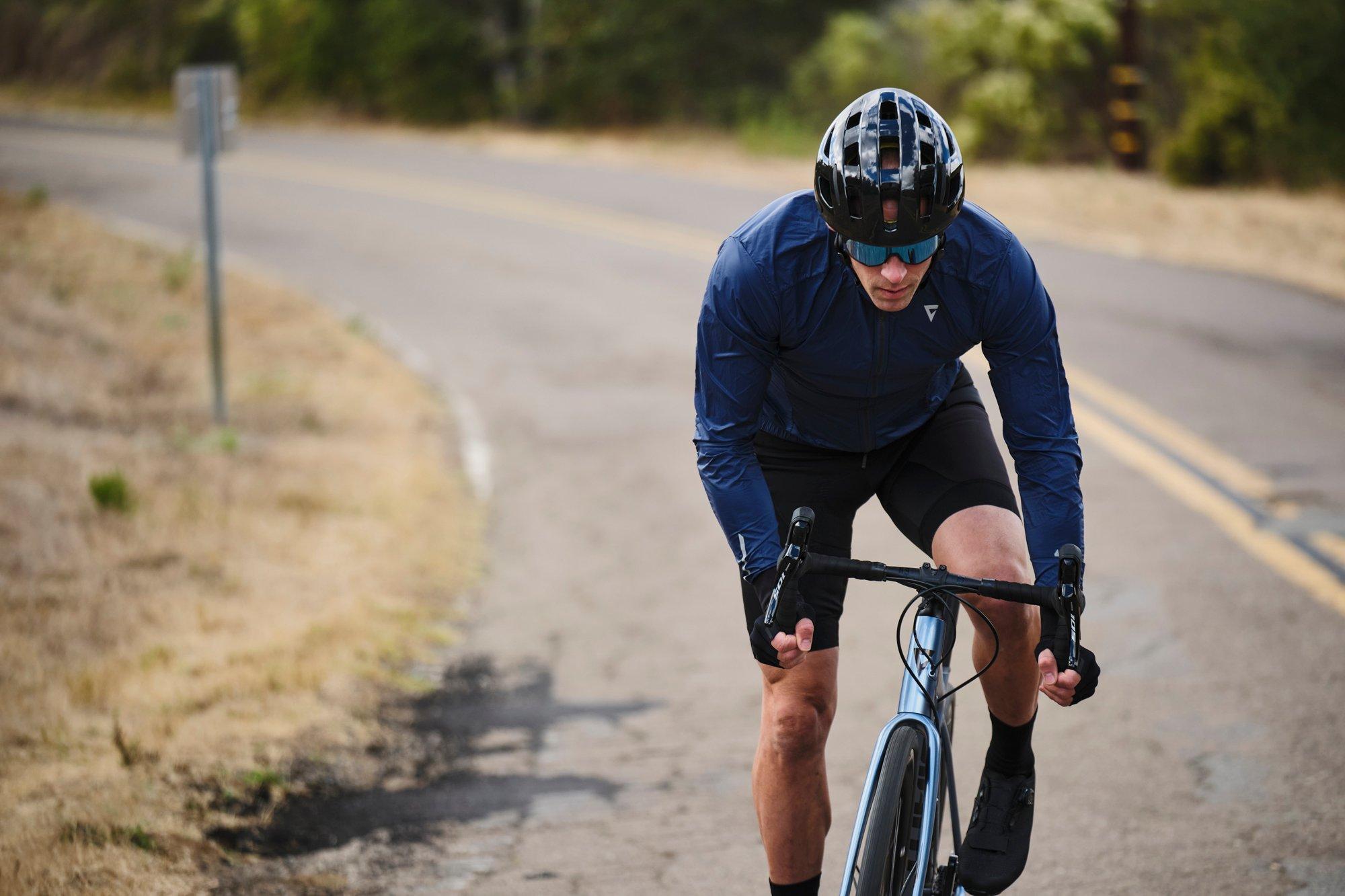 a man riding a bike down a road in the middle of the day
