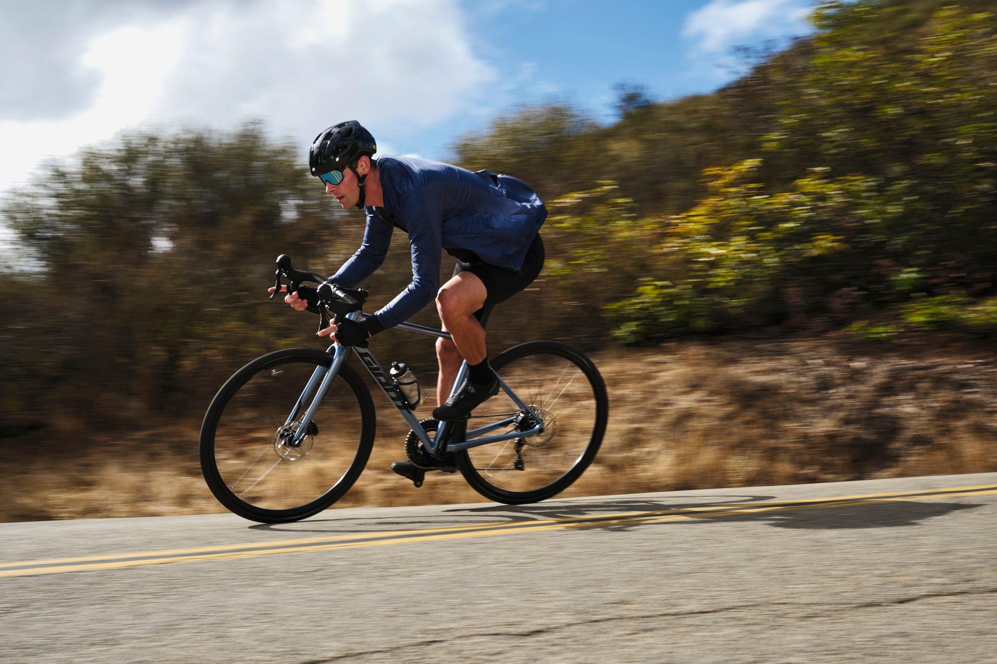 a man riding a bike down a road on a sunny day