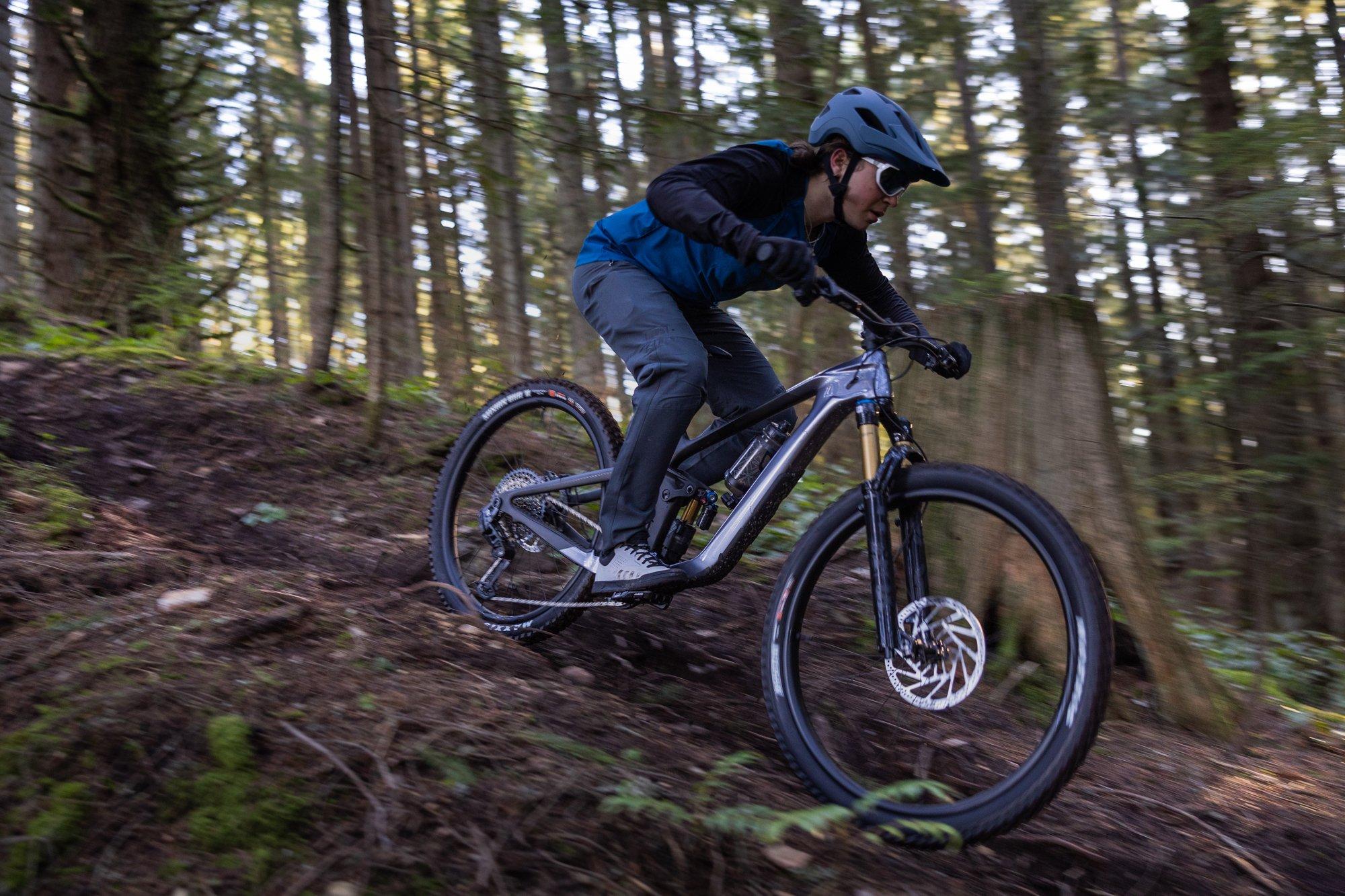 a man riding a mountain bike down a trail in the woods