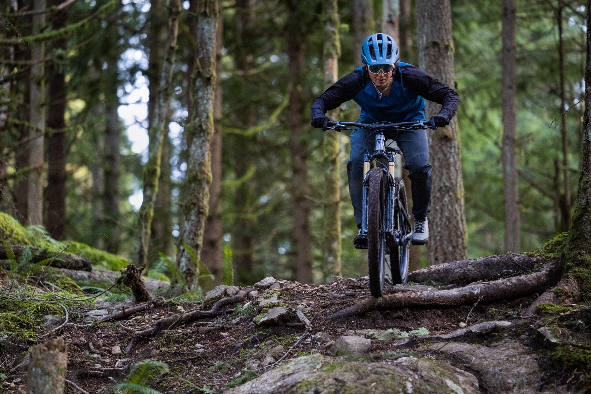 a man riding a mountain bike on a trail in the woods